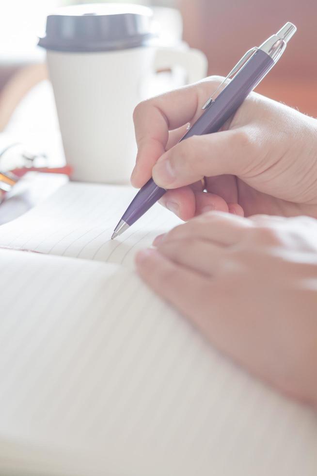 persona tomando notas en un cuaderno foto