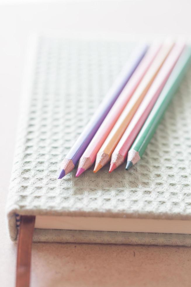 Close-up of color pencils with a green notebook photo