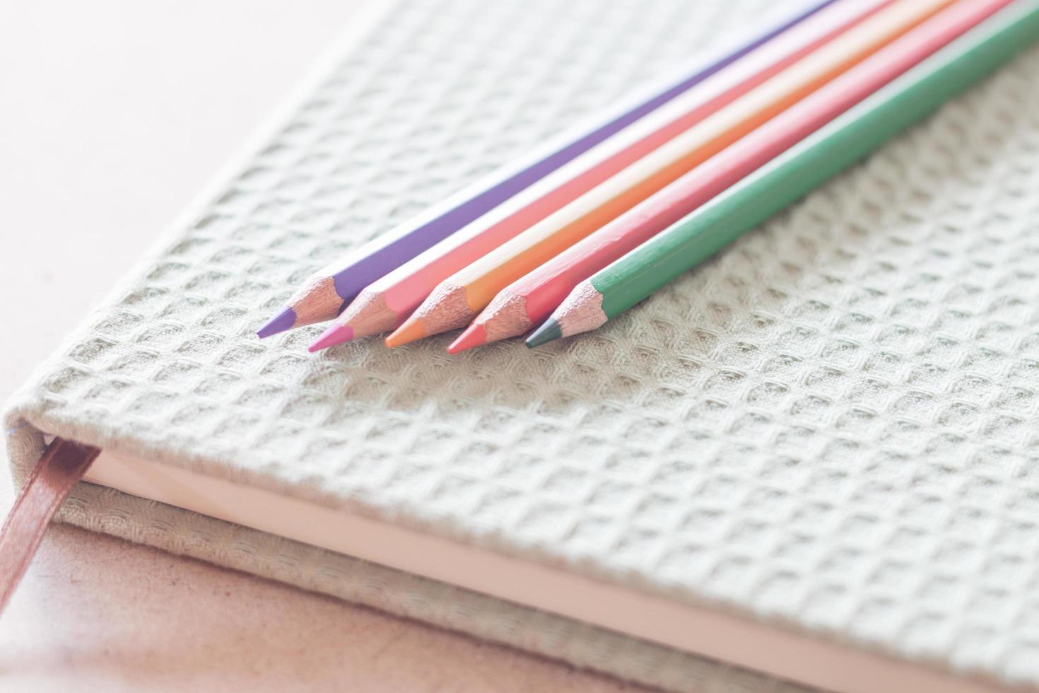 Close-up of colorful pencils on a green notebook photo