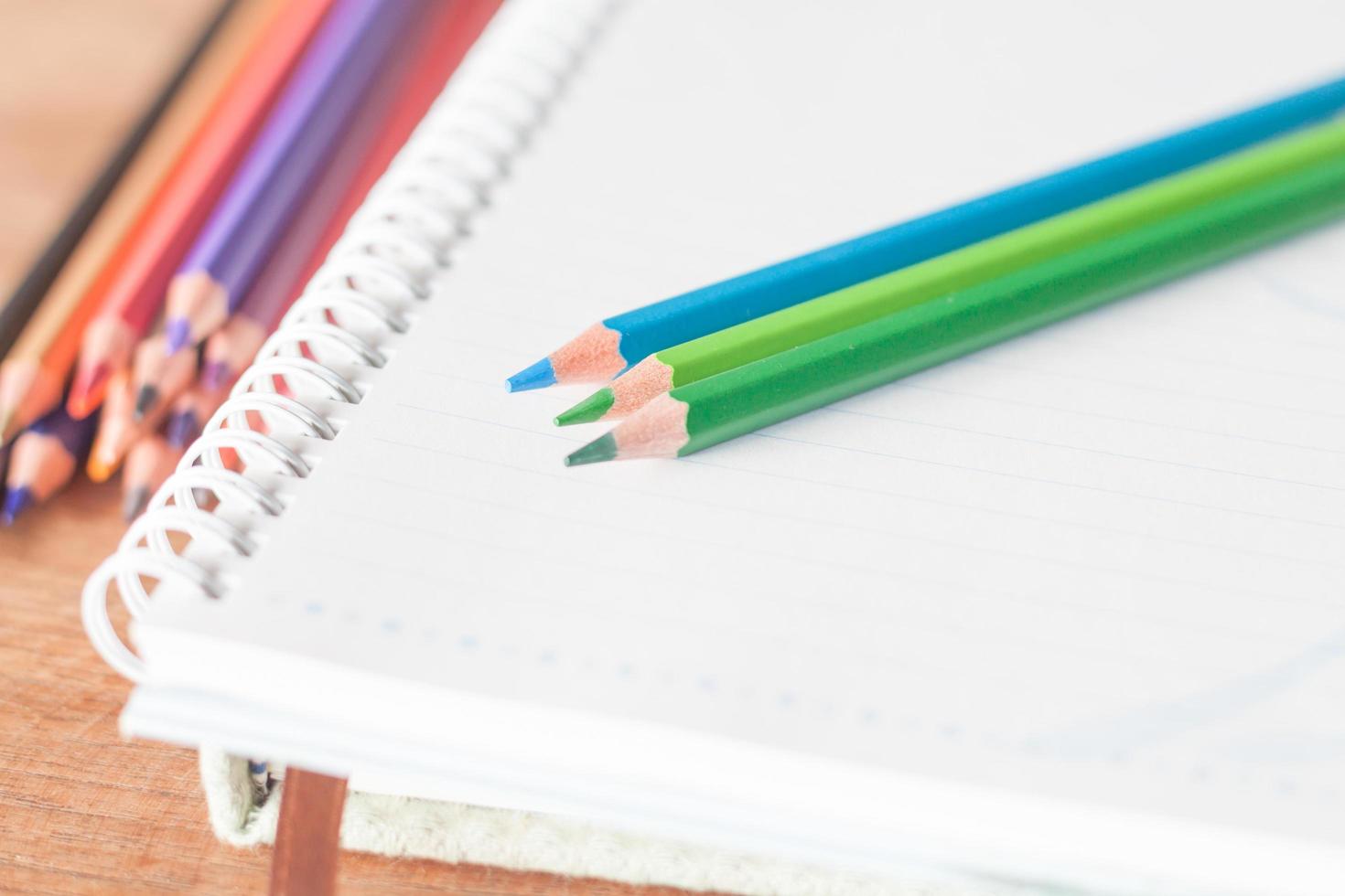 Close-up of colorful pencils on a spiral notebook photo