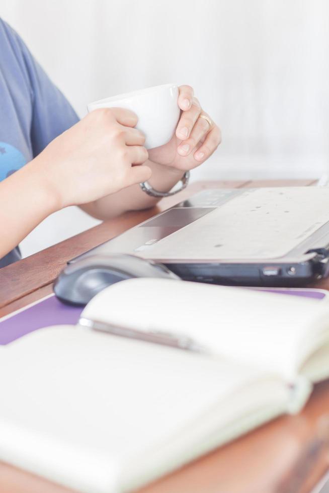 Woman drinking coffee at her desk photo