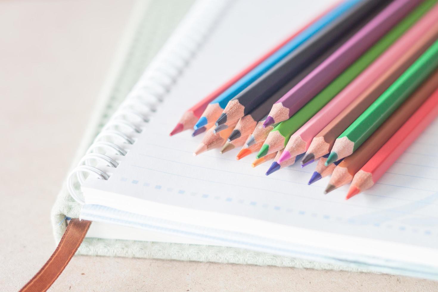 Close-up of colorful pencils on a notebook photo