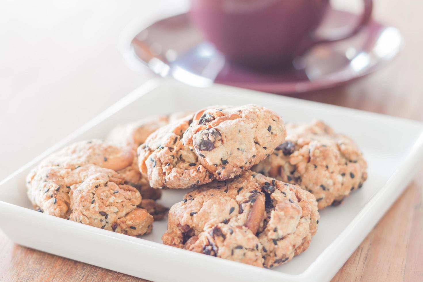 Close-up de galletas de nueces mixtas con una taza de café púrpura foto