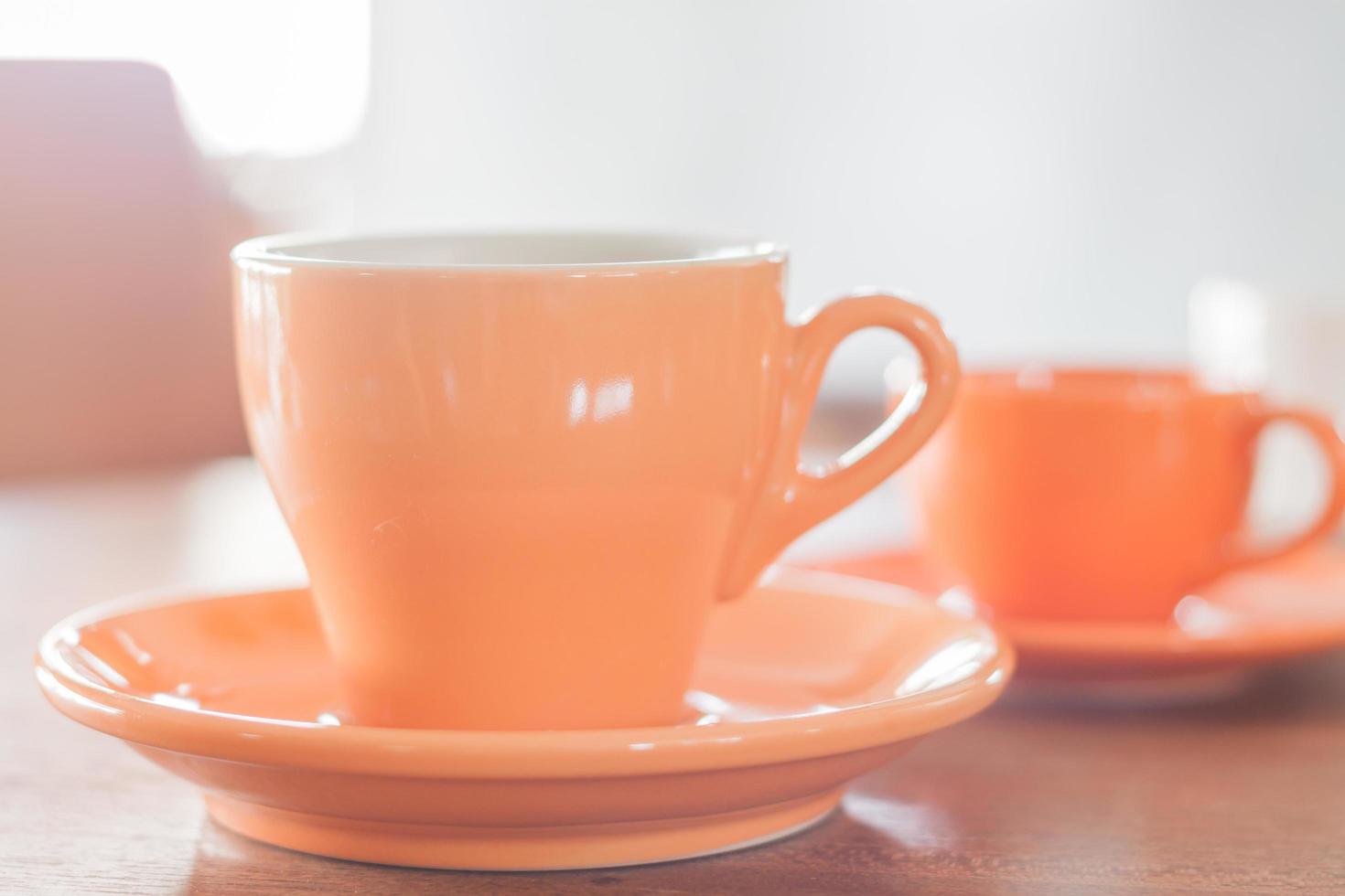 taza de café naranja y una mini taza de café naranja foto
