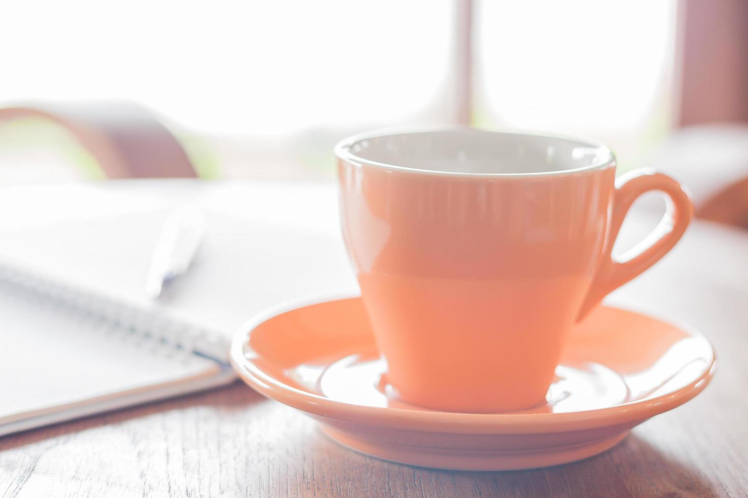 Close-up of an orange coffee cup in a coffee shop photo