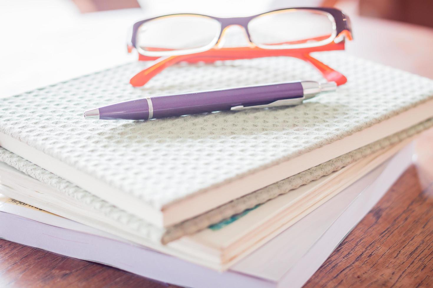 Pen and eyeglasses on notebooks photo