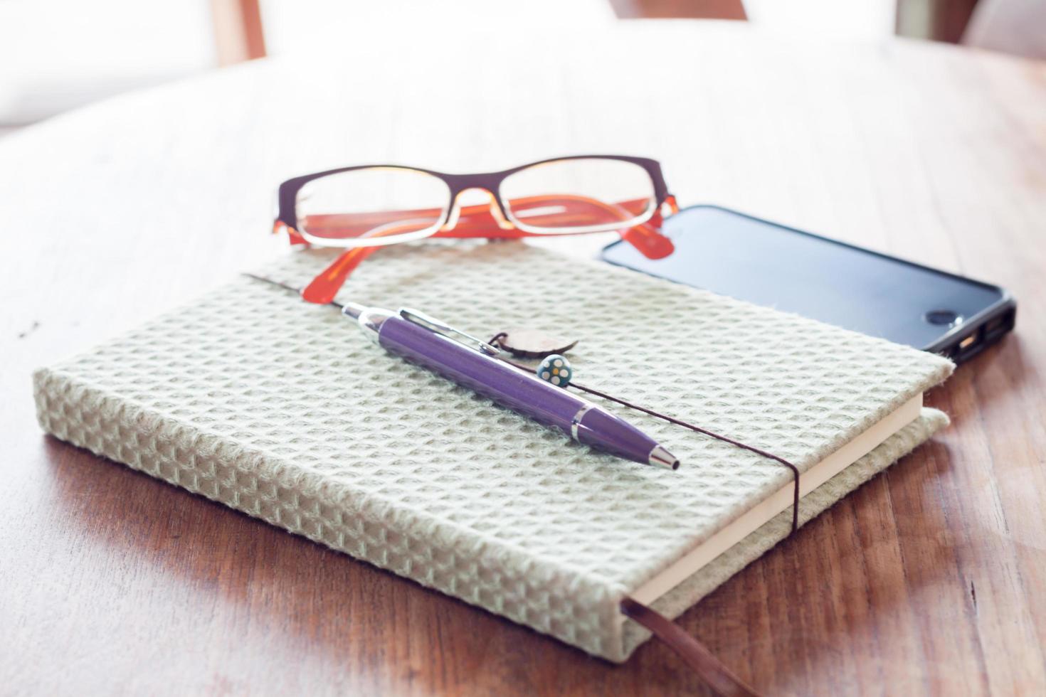 Notebook and pen with a smartphone on a wooden table photo