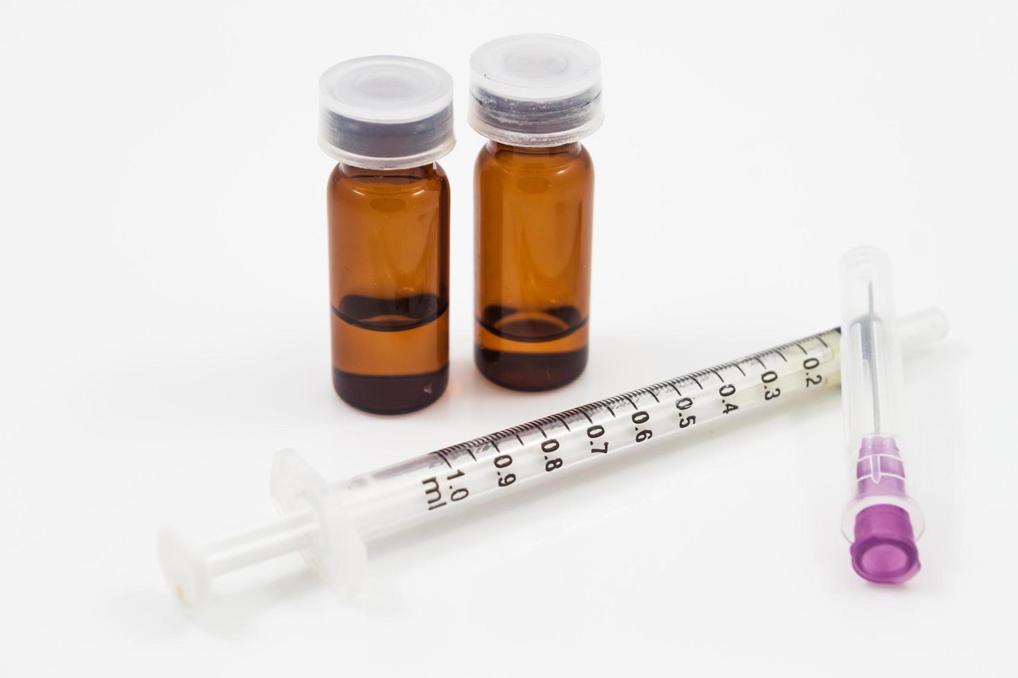 Medicine vials and syringe isolated on a white background photo