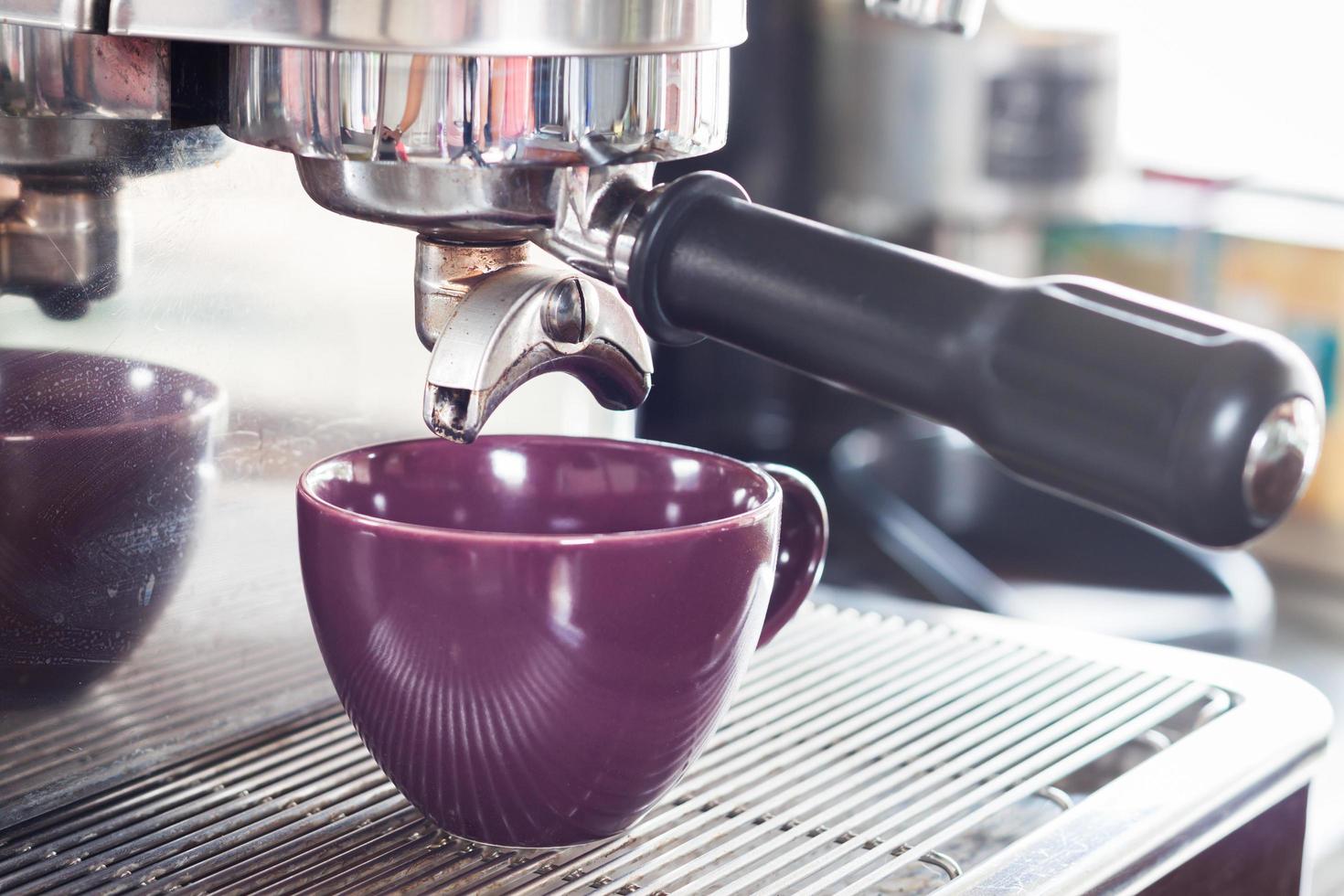 goteo de espresso y una taza morada foto