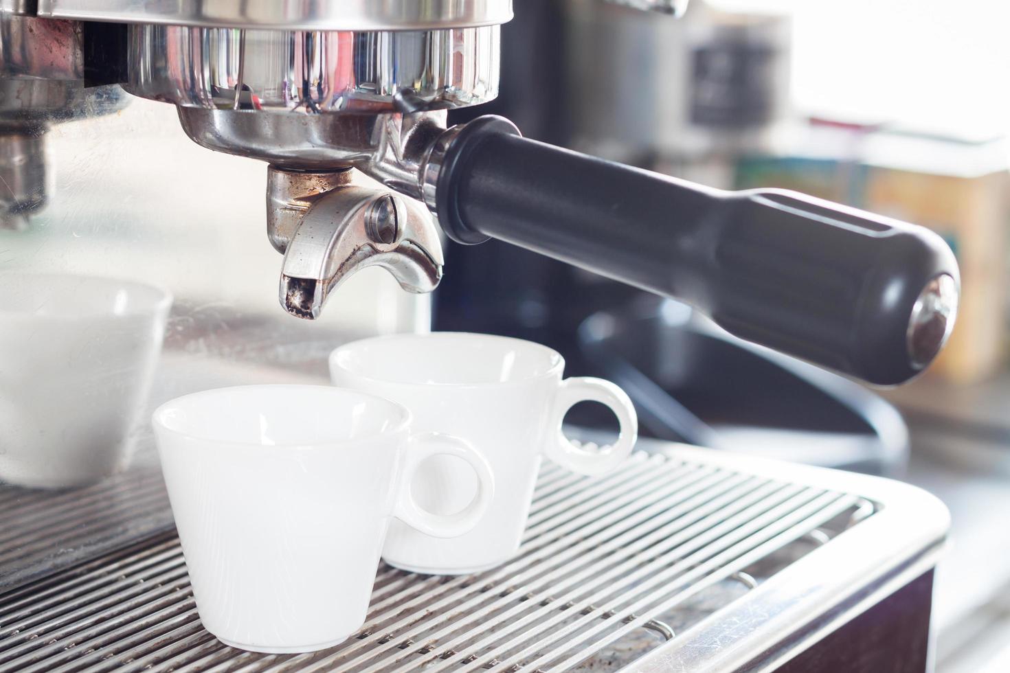 tazas de espresso debajo de un goteo de espresso foto