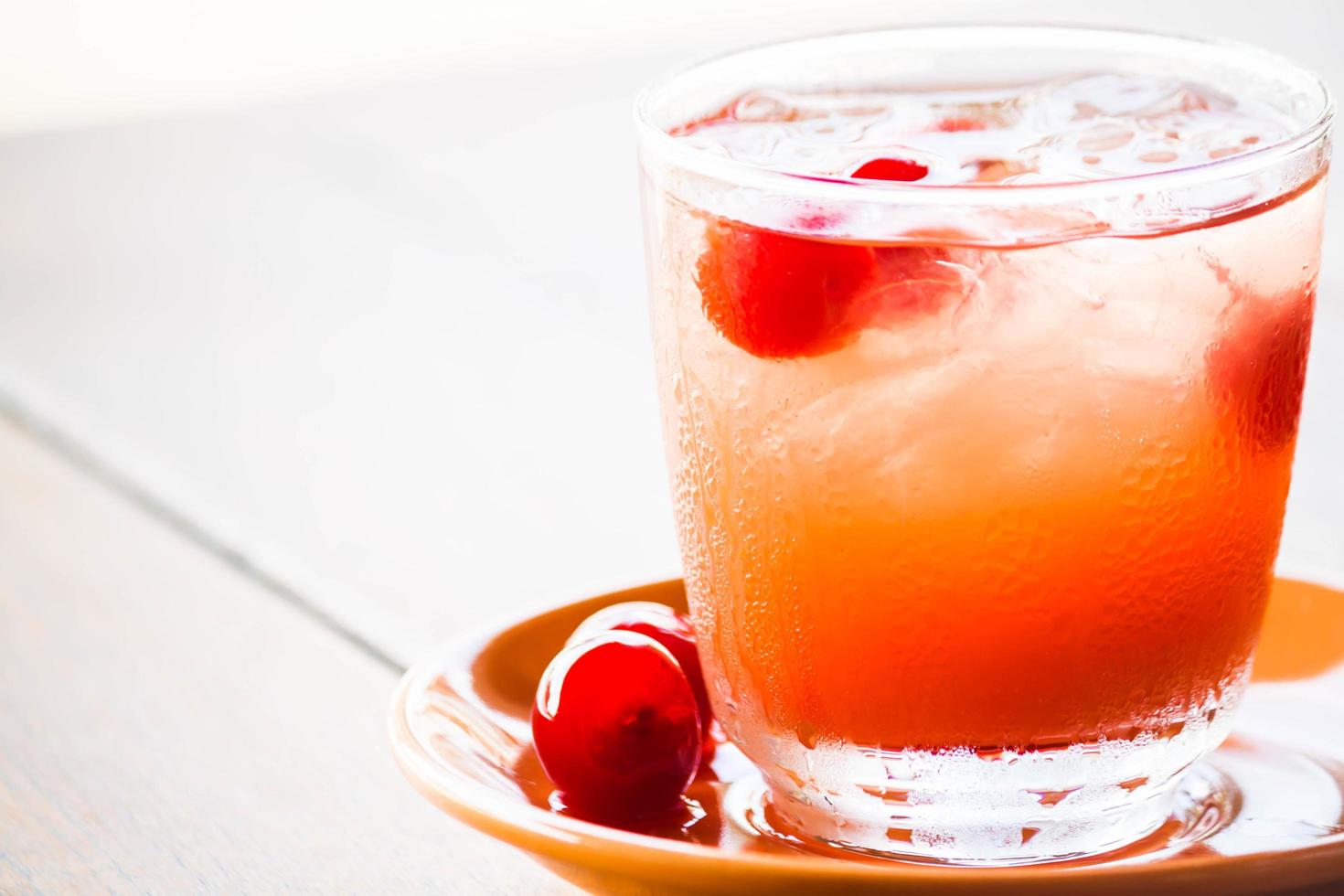 bebida de cereza en mesa blanca foto
