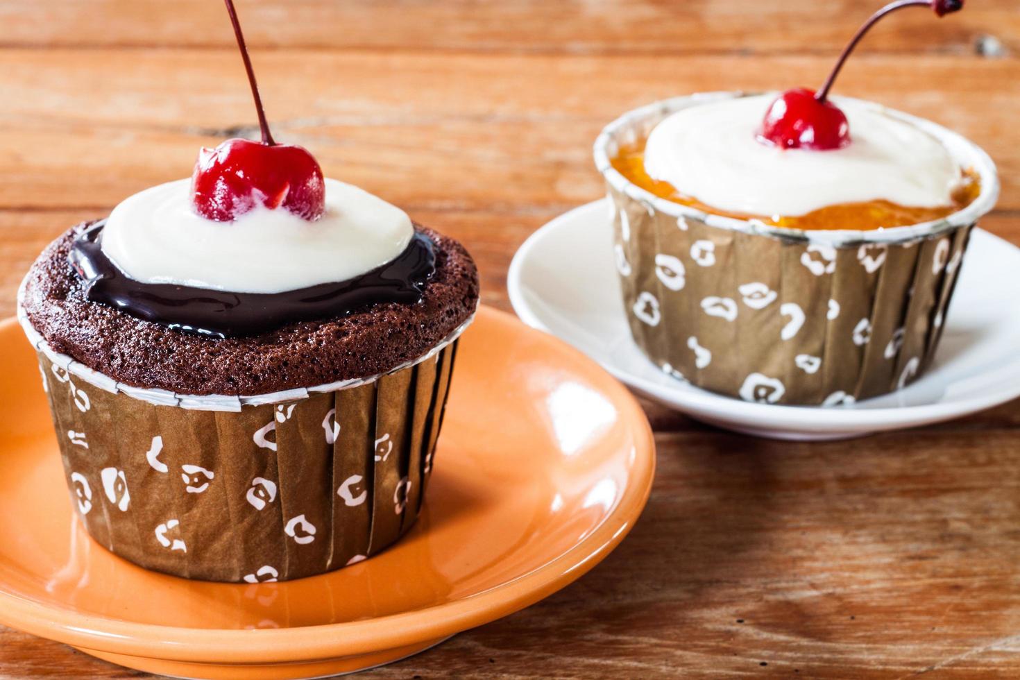 cupcakes de mermelada de chocolate y mantequilla decorados con cereza roja foto