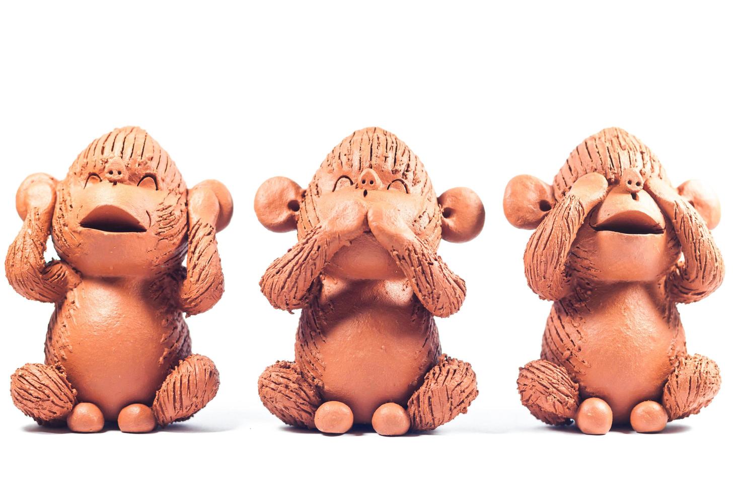 Three clay monkeys on a white background photo