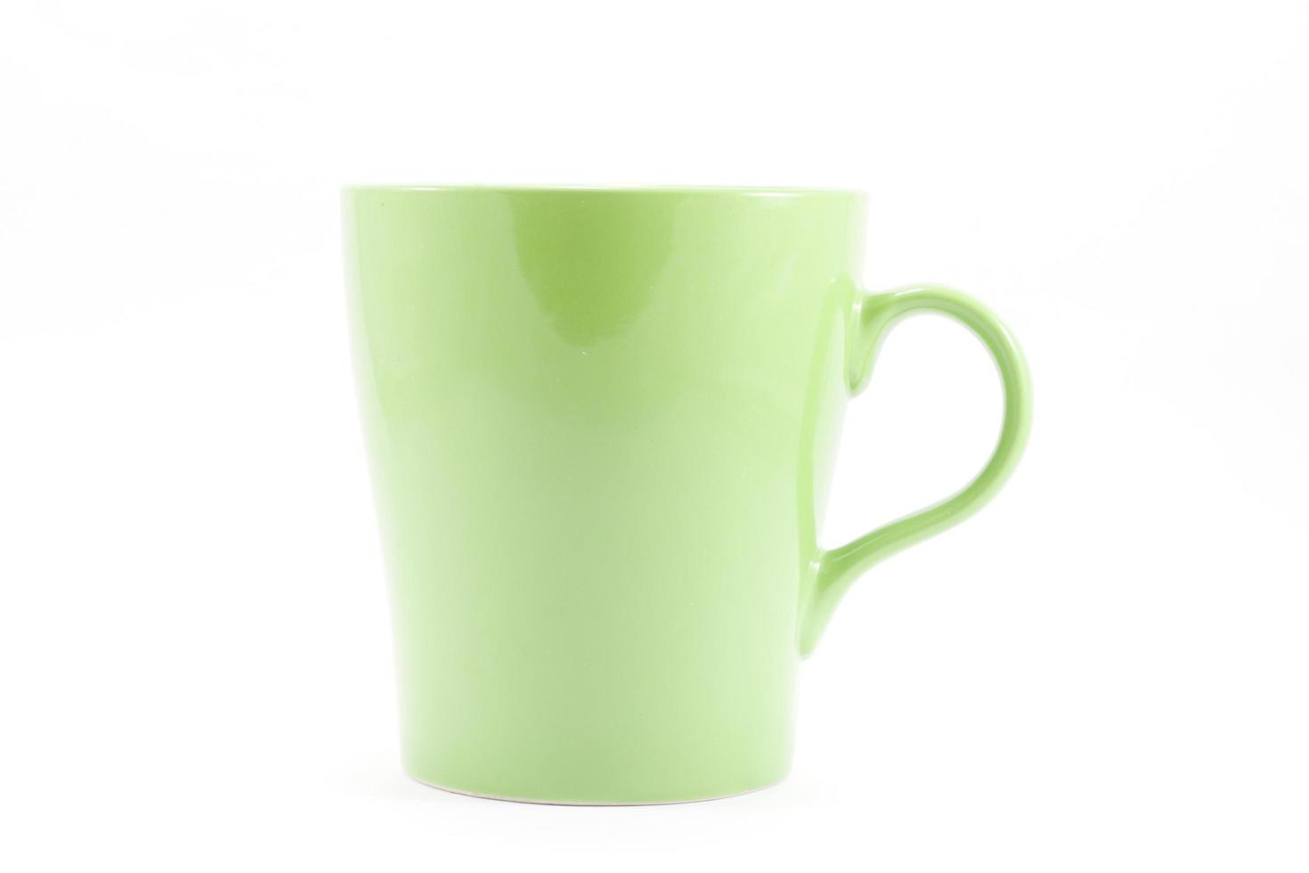 Taza verde sobre un fondo blanco. foto