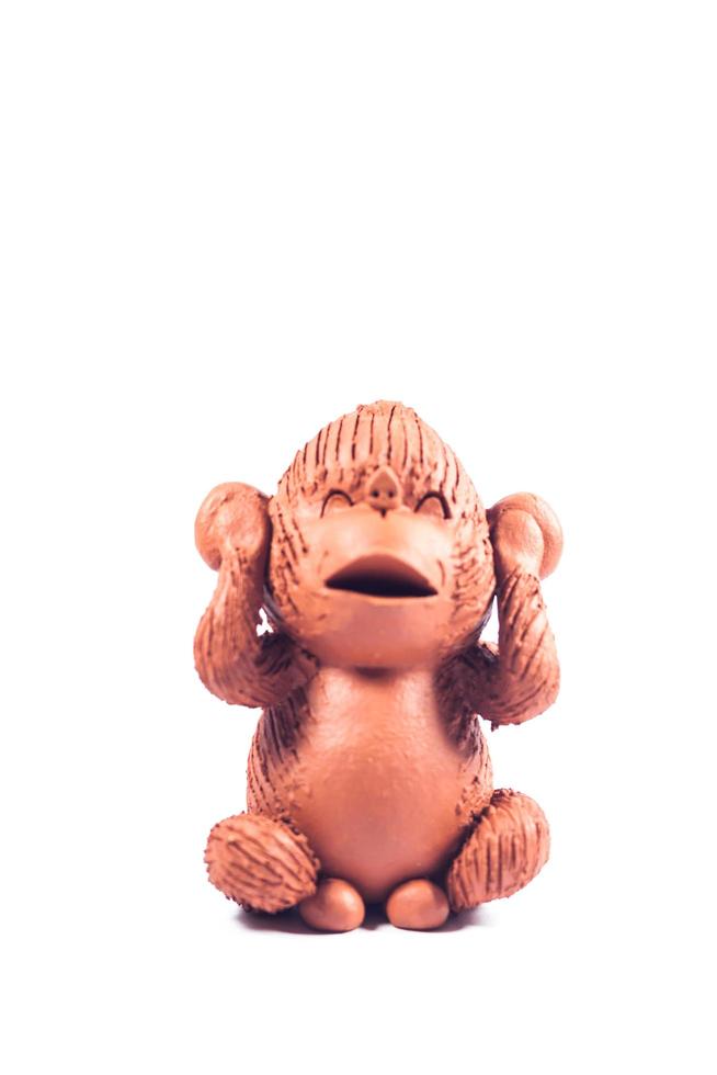 Close-up of clay monkey covering ears photo