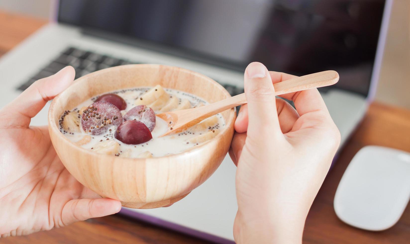 Close-up of person eating oatmeal at their desk photo