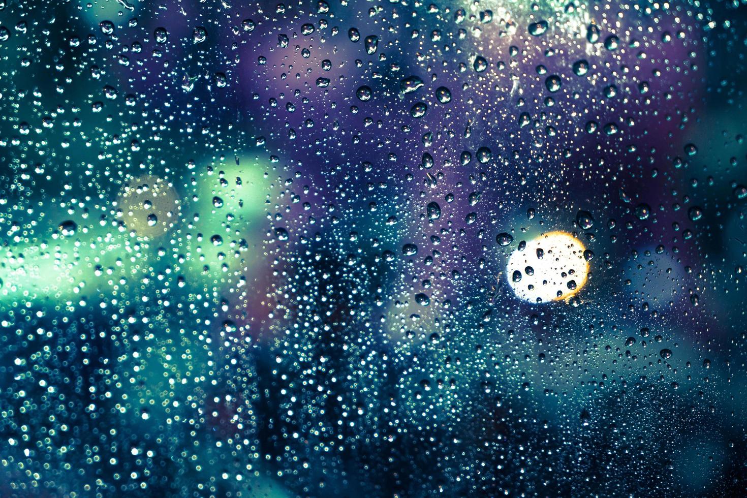 gotas de lluvia en la ventana con colorido bokeh foto