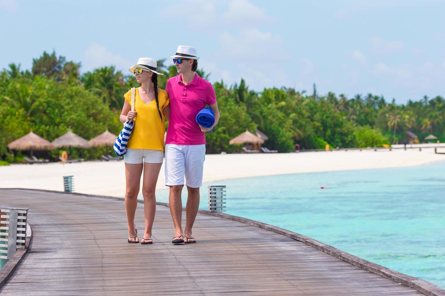 Maldivas, Asia del Sur, 2020 - una pareja caminando en un muelle junto al océano foto