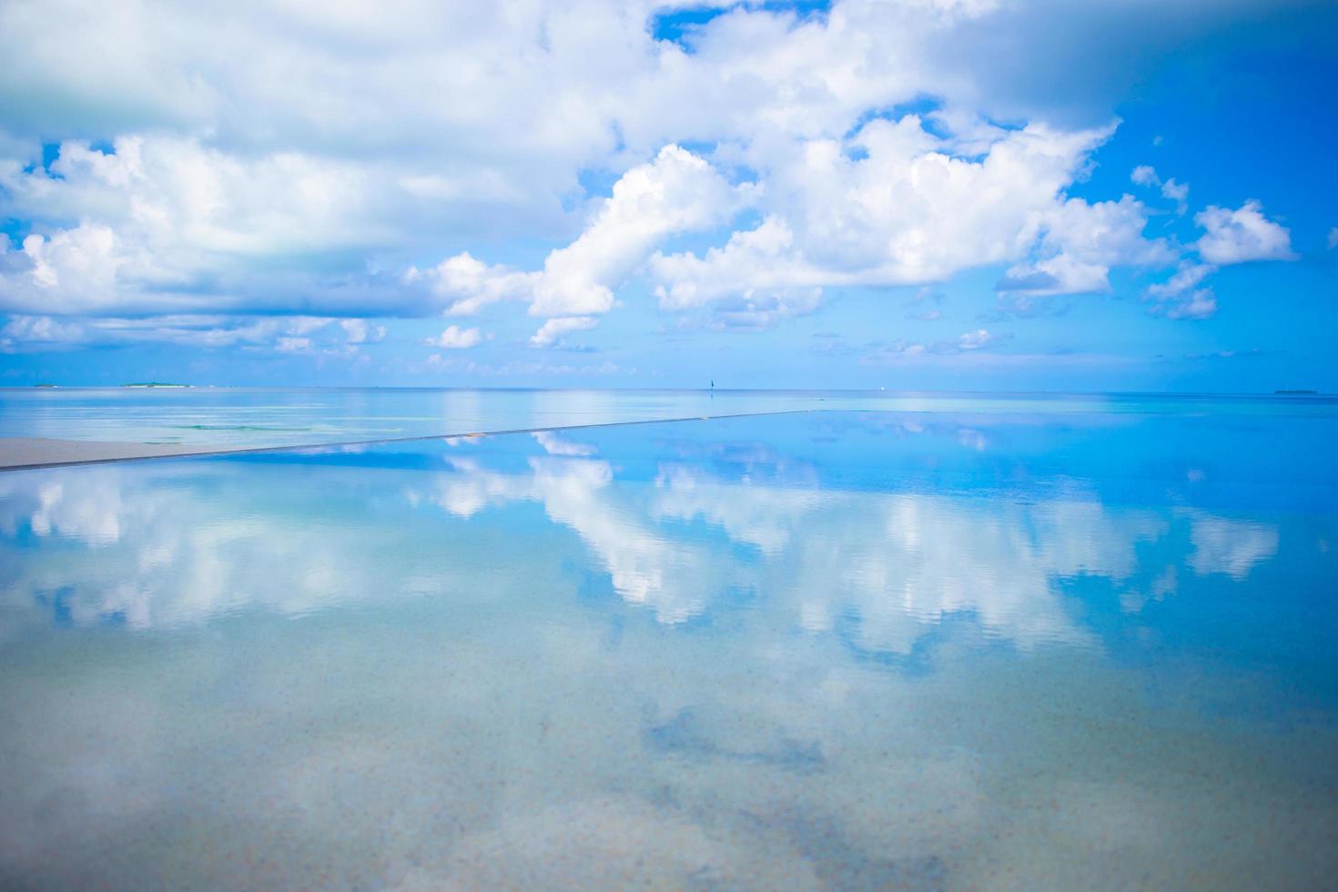 Reflection of clouds in still water photo