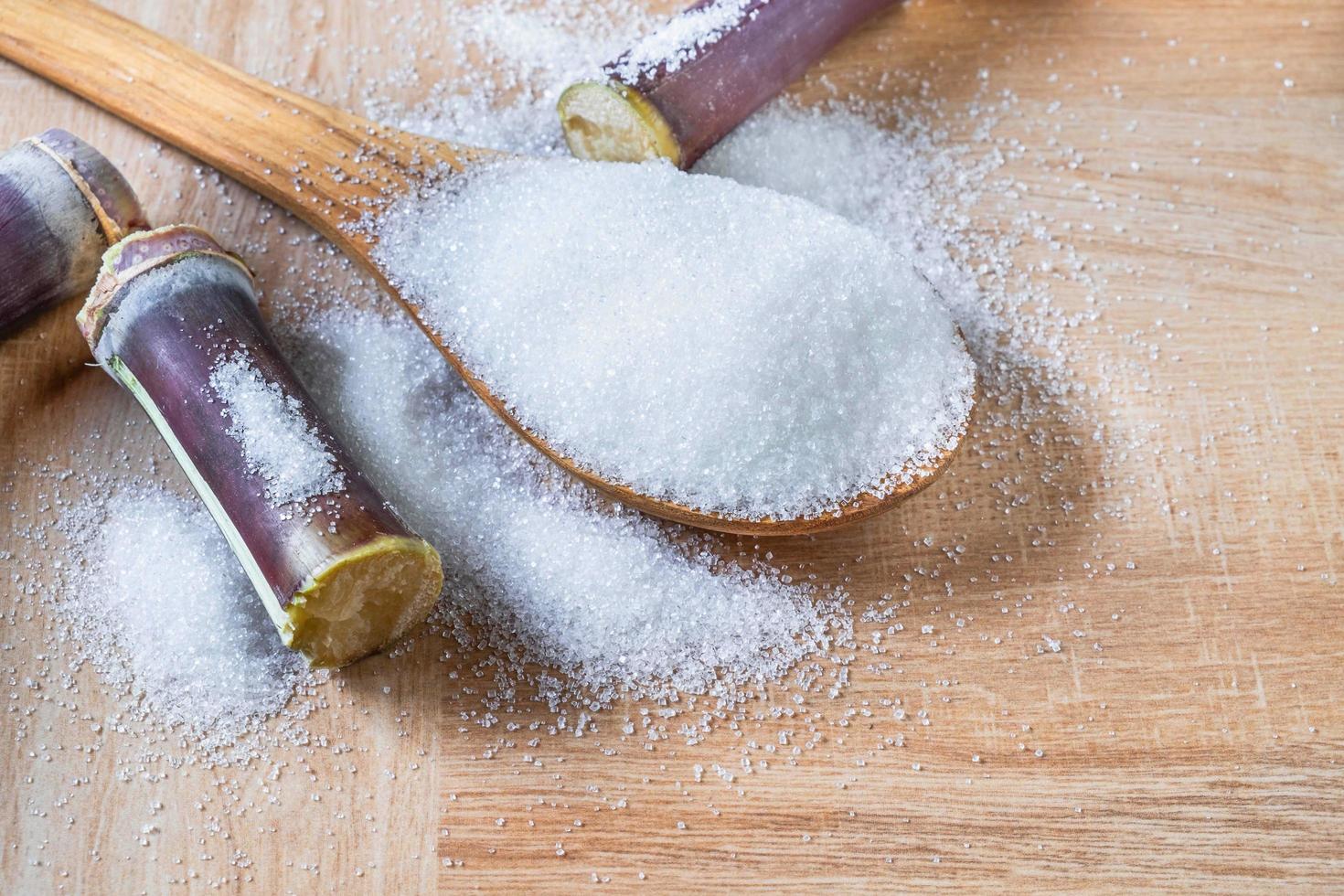 White sugar on wooden spoon photo