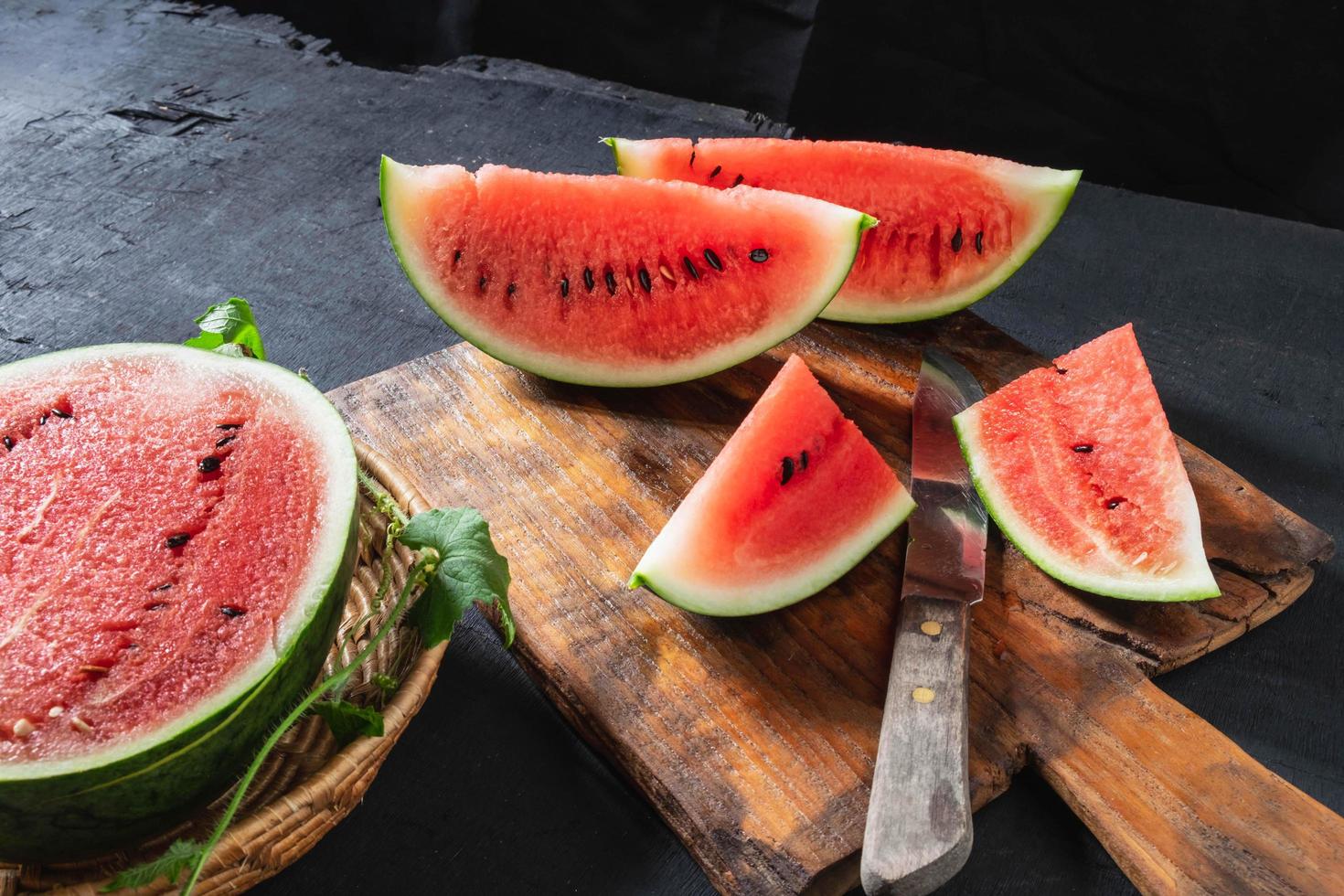 Watermelon slices cut in half on a wooden cutting board photo