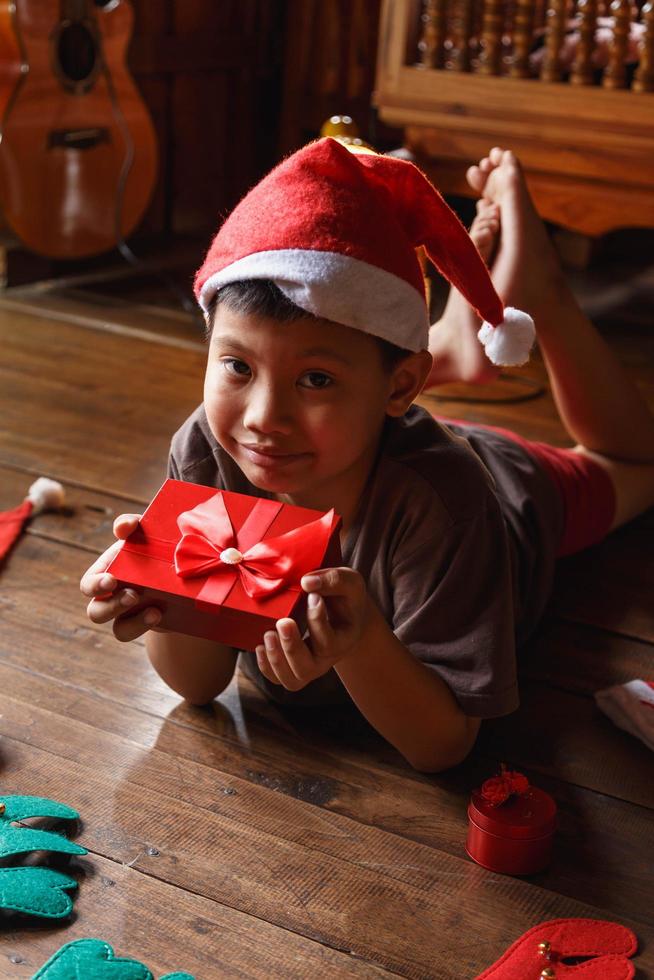 niño con caja de regalo el día de navidad foto