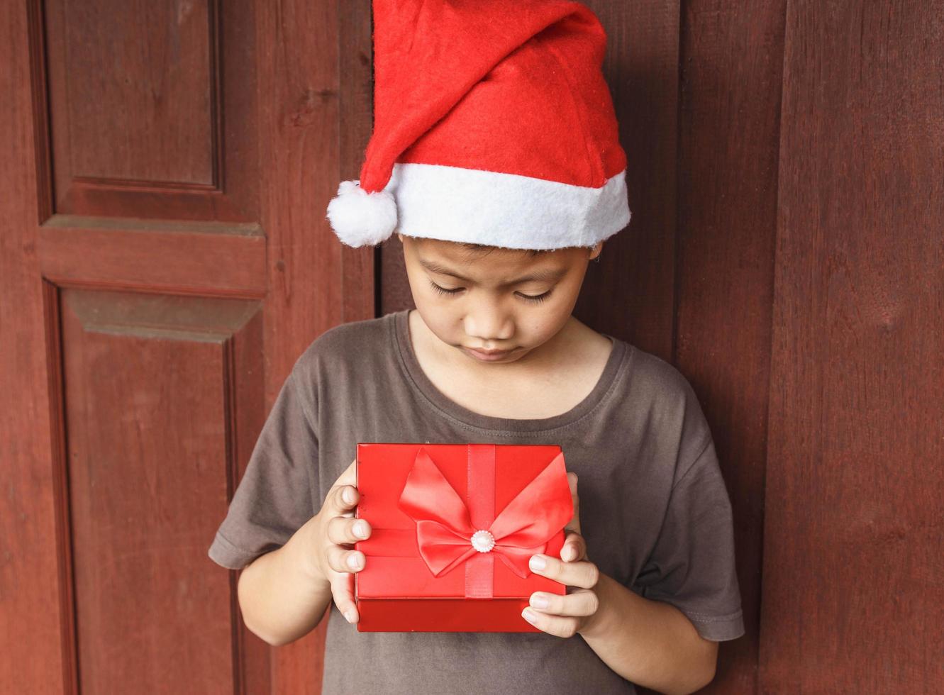 niño con caja de regalo el día de navidad foto