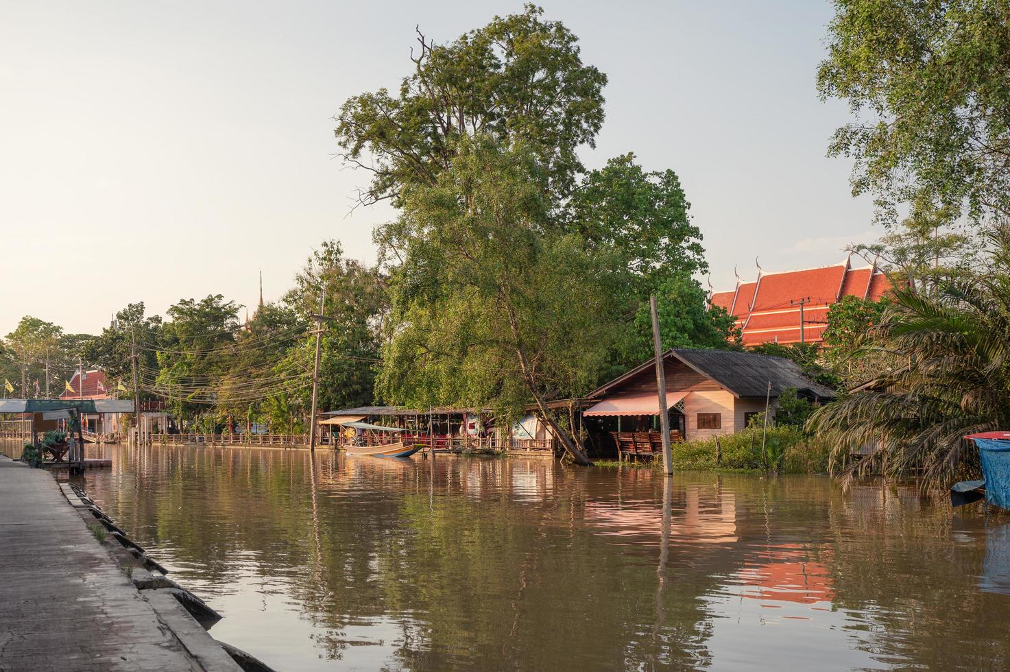 Casa de familia de madera flotando en la orilla del río. foto