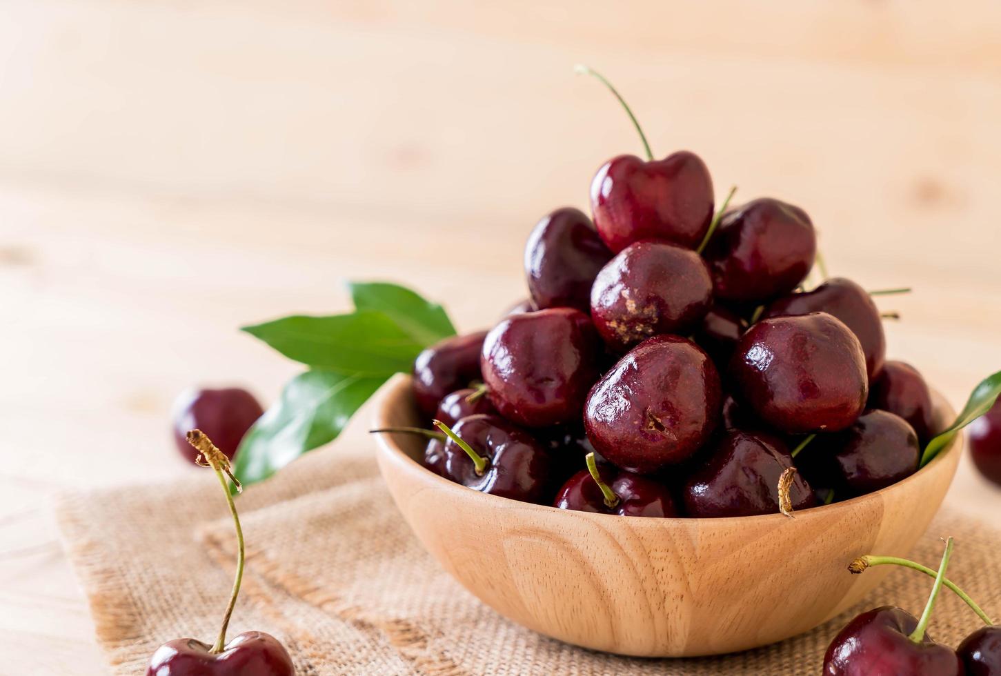 cerezas frescas en un cuenco de madera foto