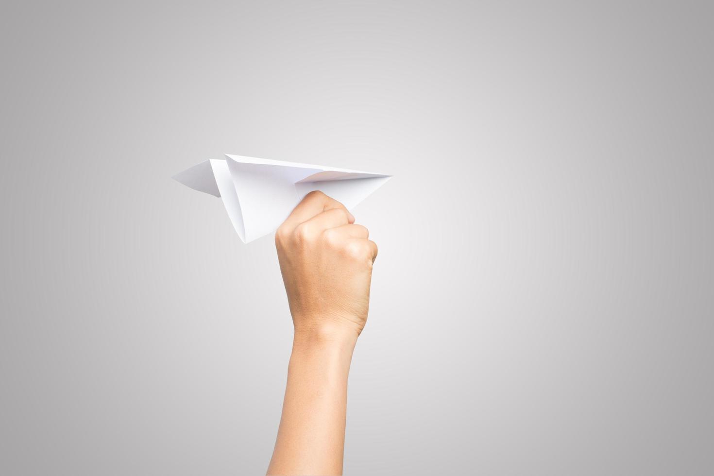 A woman's hand holds a paper airplane on white background photo