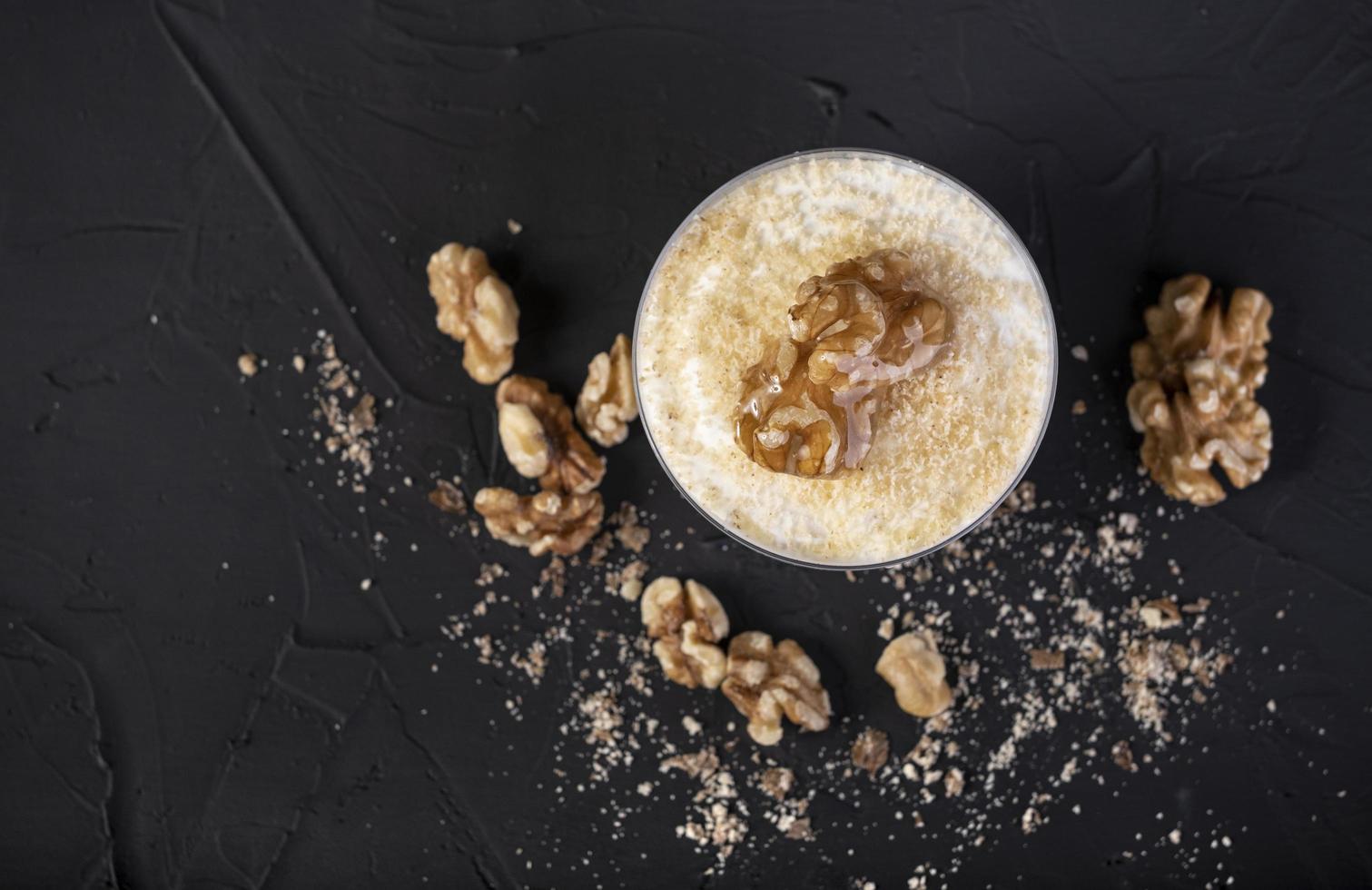 White chocolate mousse covered with nuts on a black background photo