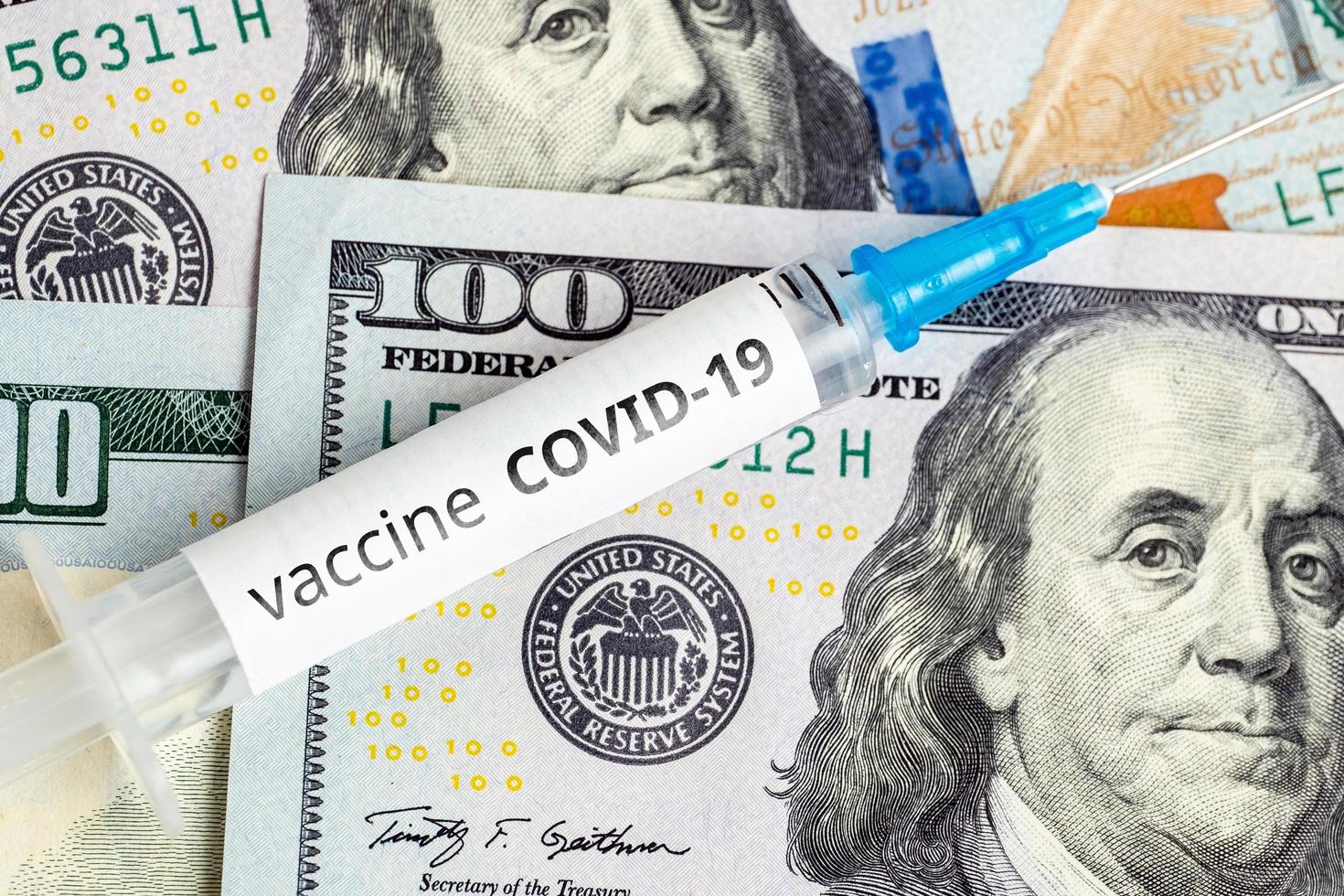 Covid-19 vaccine on dollar bills photo