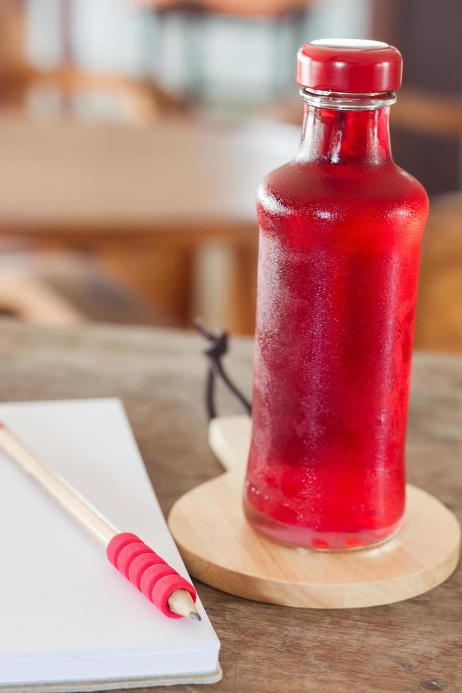 refresco rojo en una botella de vidrio foto