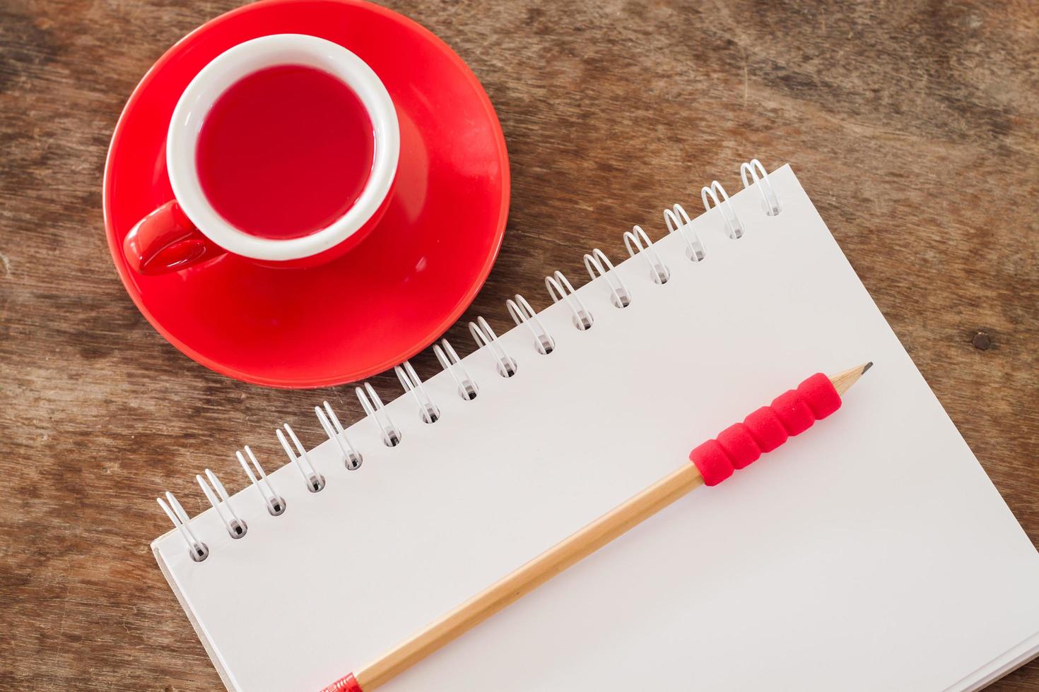 cuaderno abierto y una taza roja foto