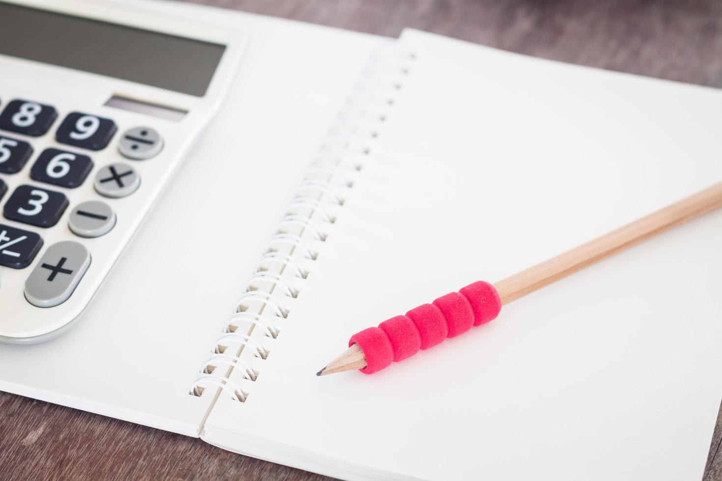 lápiz rojo y calculadora con un cuaderno foto