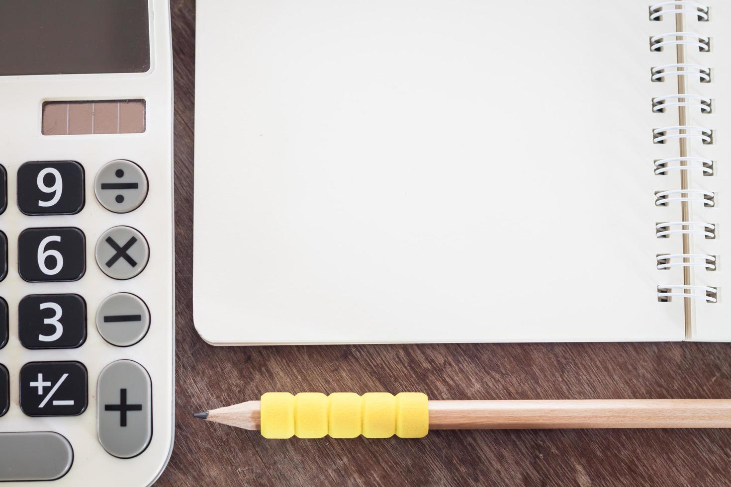 Close-up of a calculator and pencil with a notebook photo