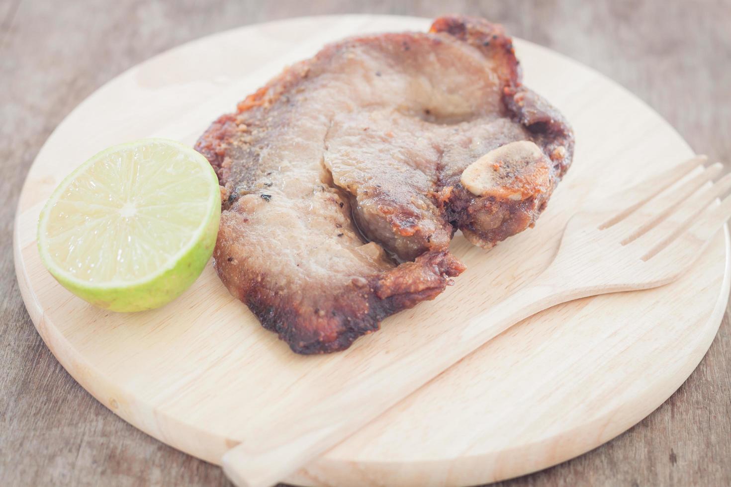 Pork steak with a lime on a plate photo