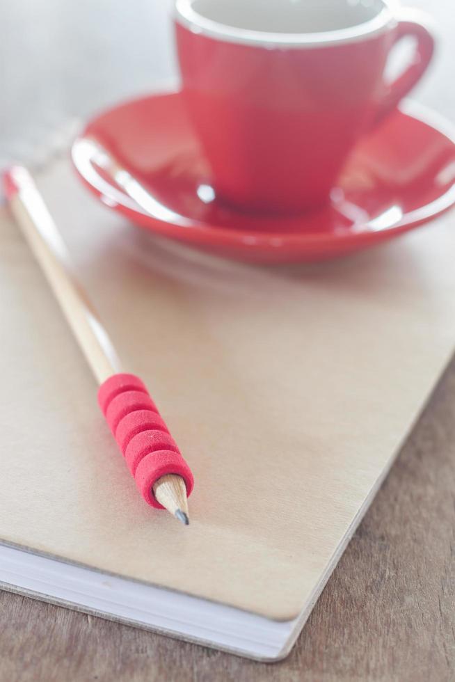 cuaderno con lápiz y taza foto