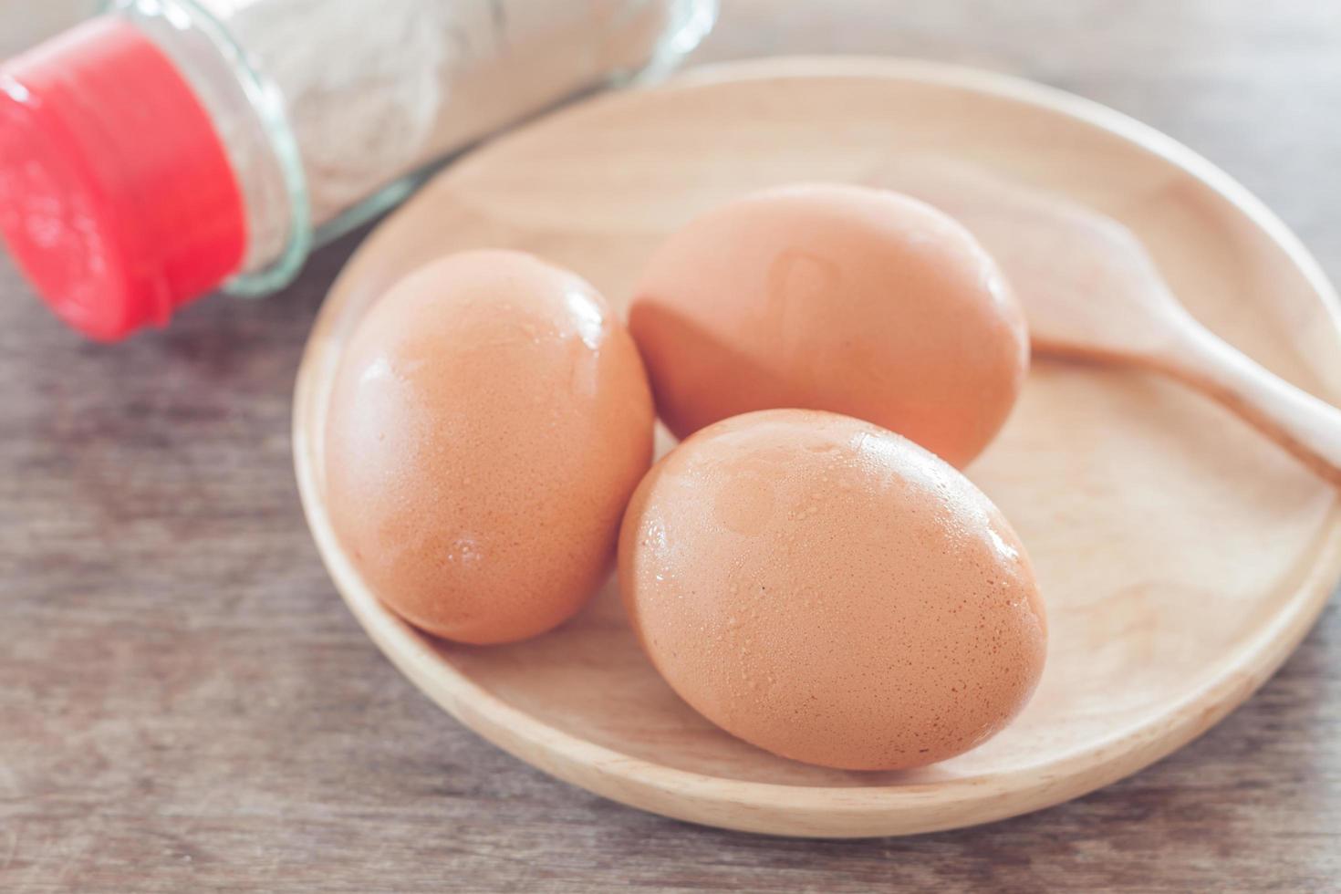 Brown eggs on a wooden plate photo