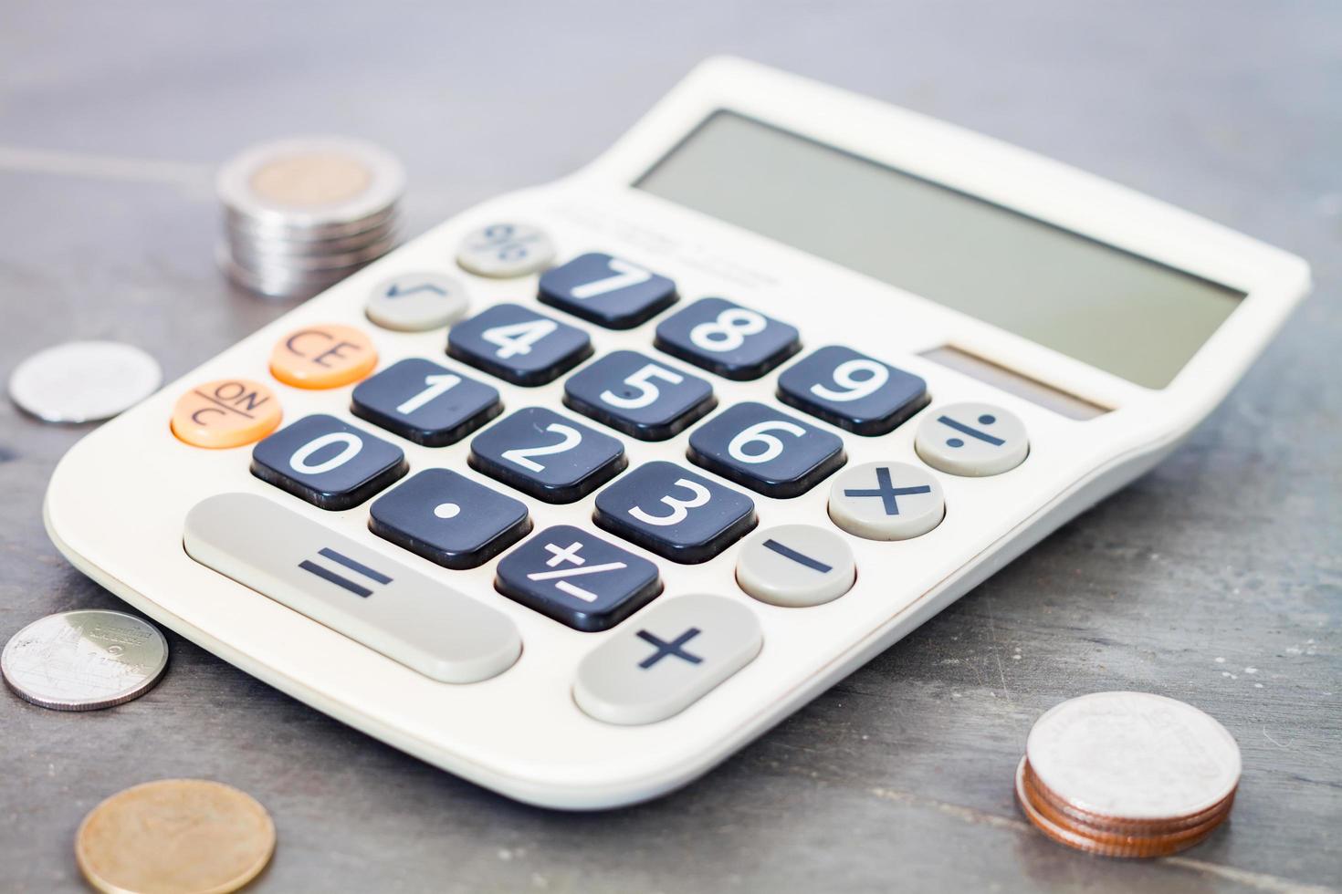 Calculator and coins on a grey background photo