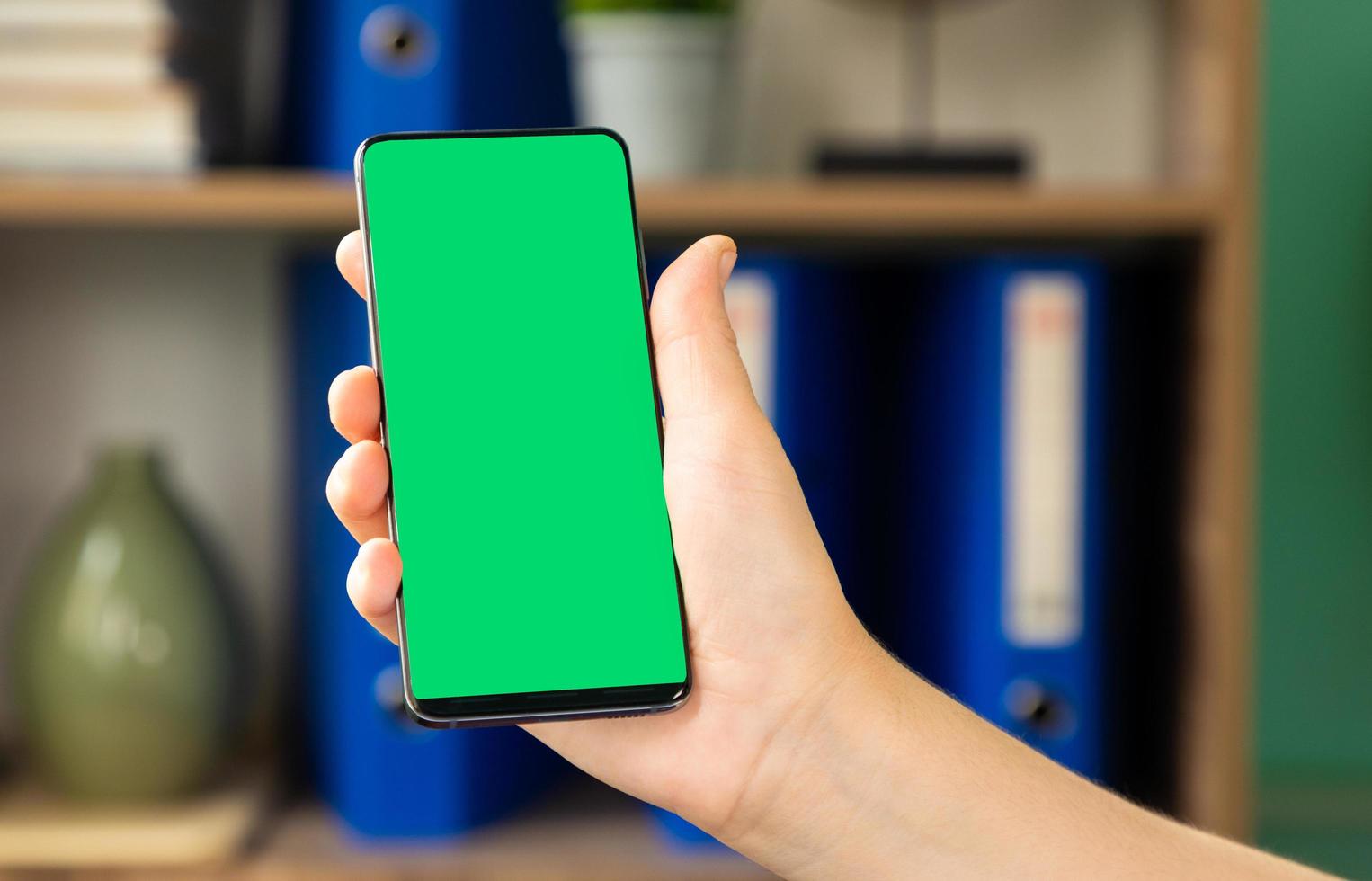 Woman holding a green screen smartphone photo