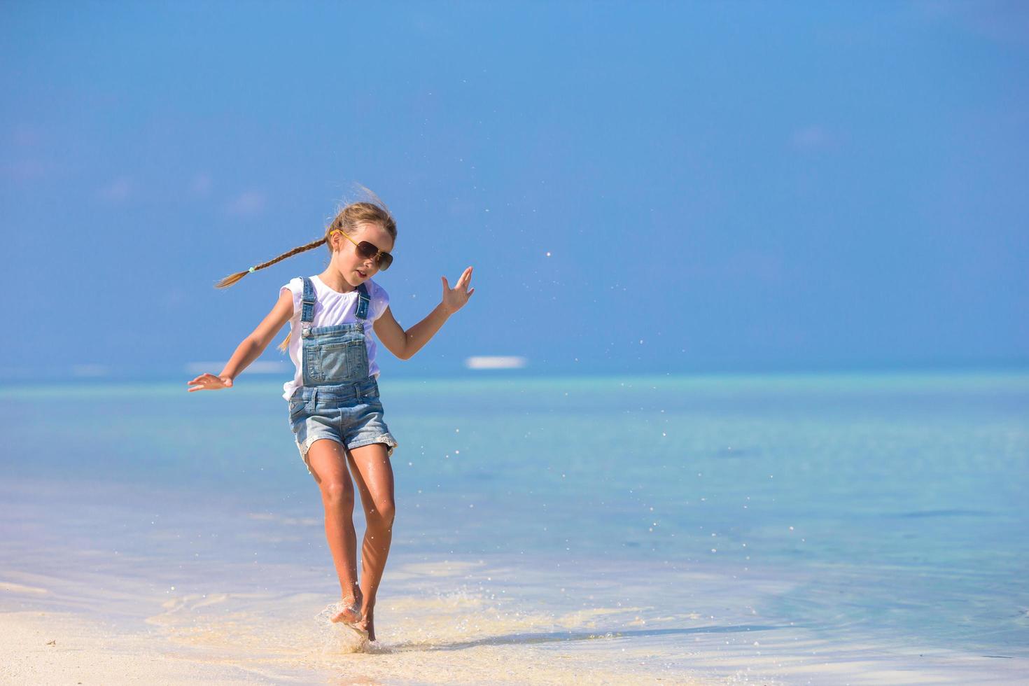 Girl playing in the water at the beach photo