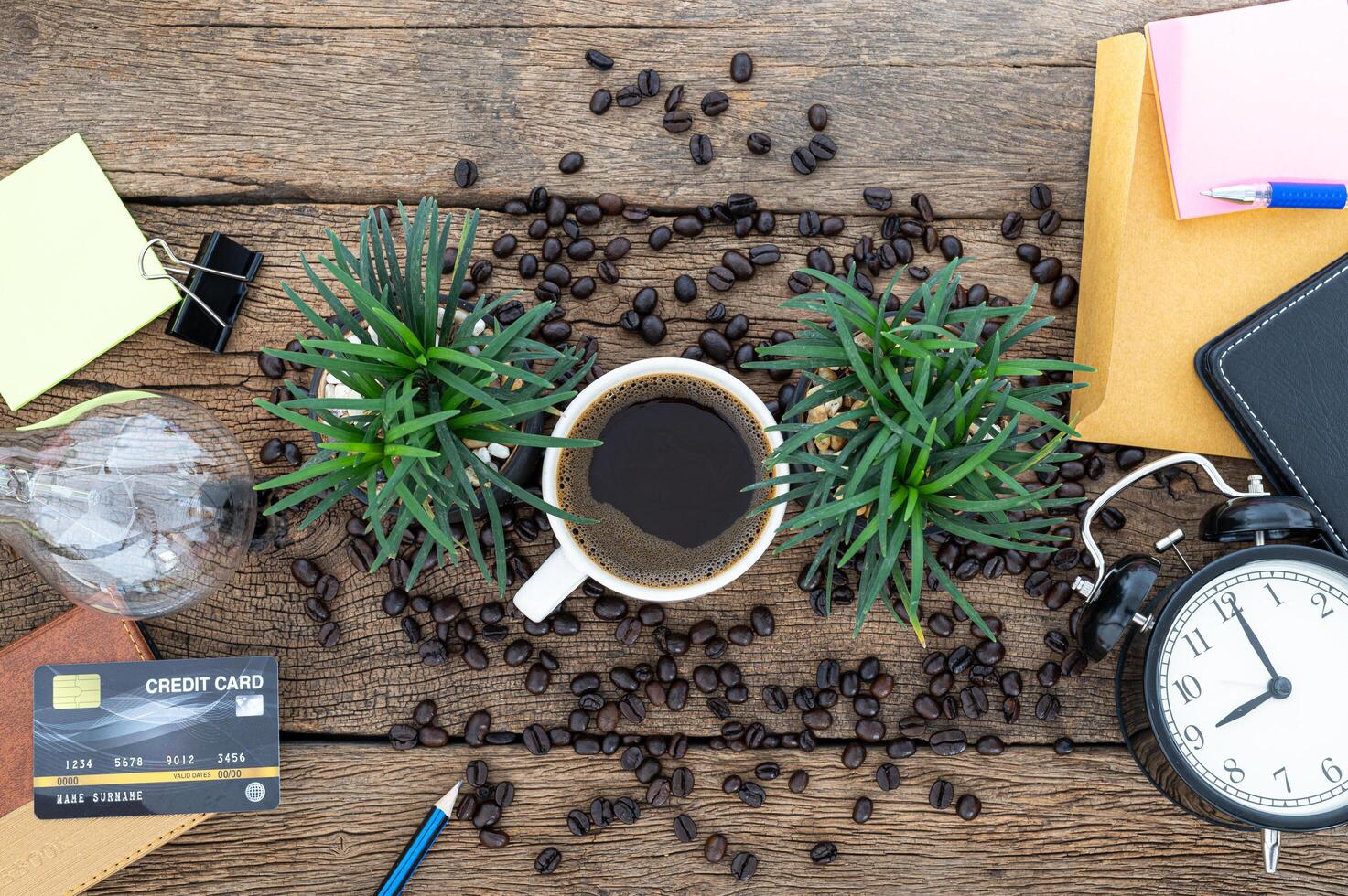 Herramientas de trabajo de oficina y café en la mesa de madera foto