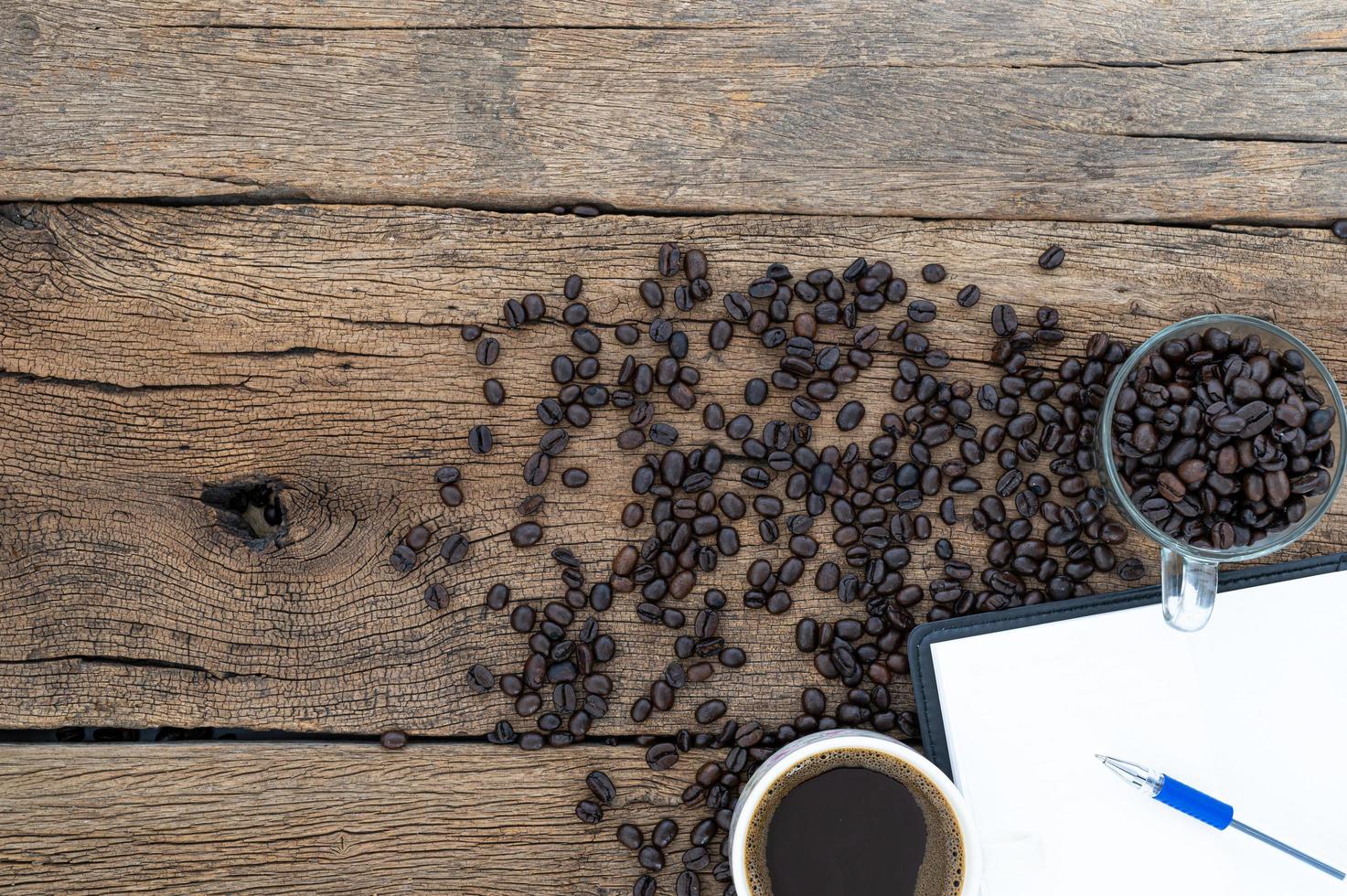 escritorio de madera con café y cuaderno foto