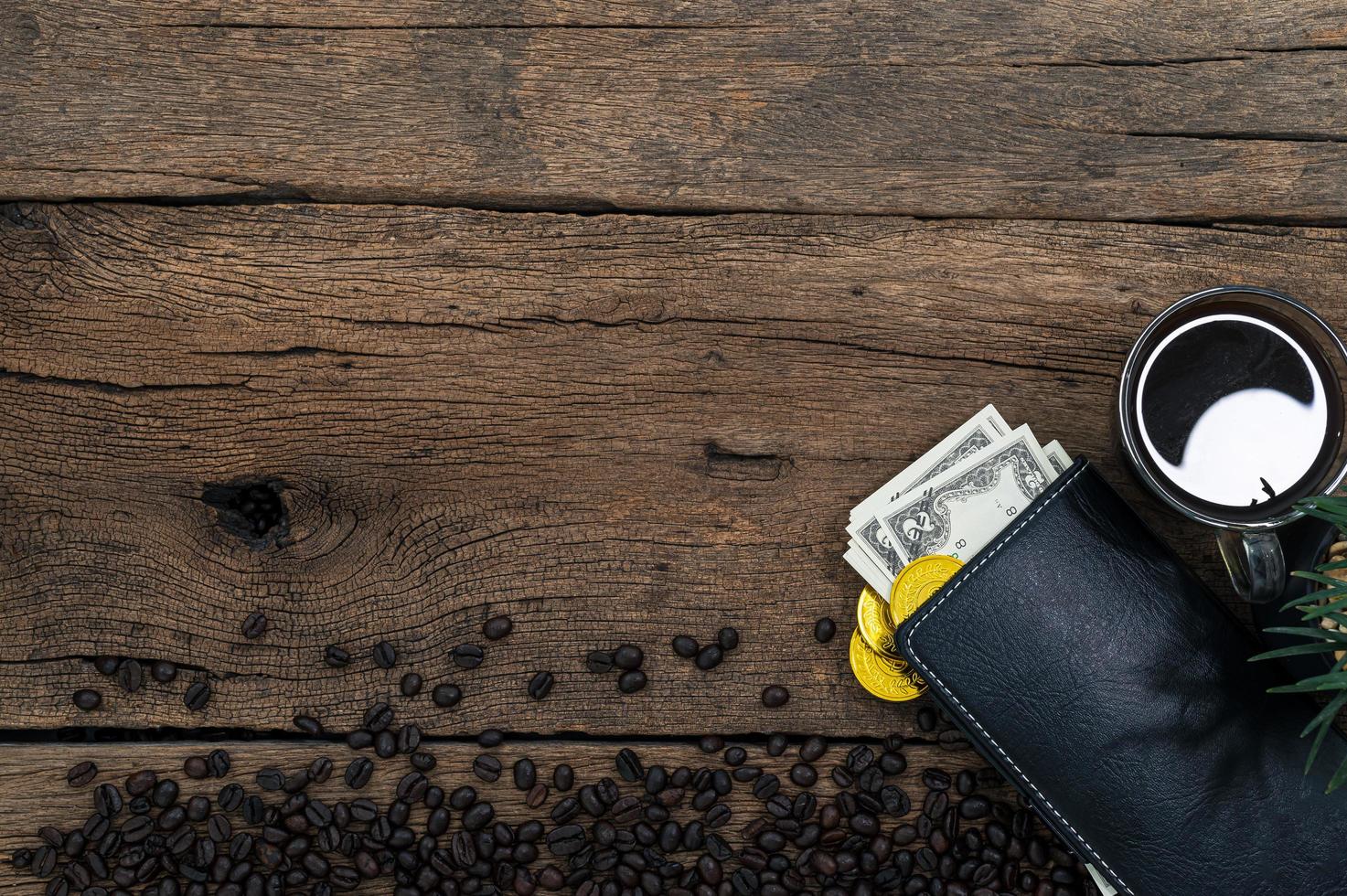 dinero y café en la mesa de madera, vista superior foto