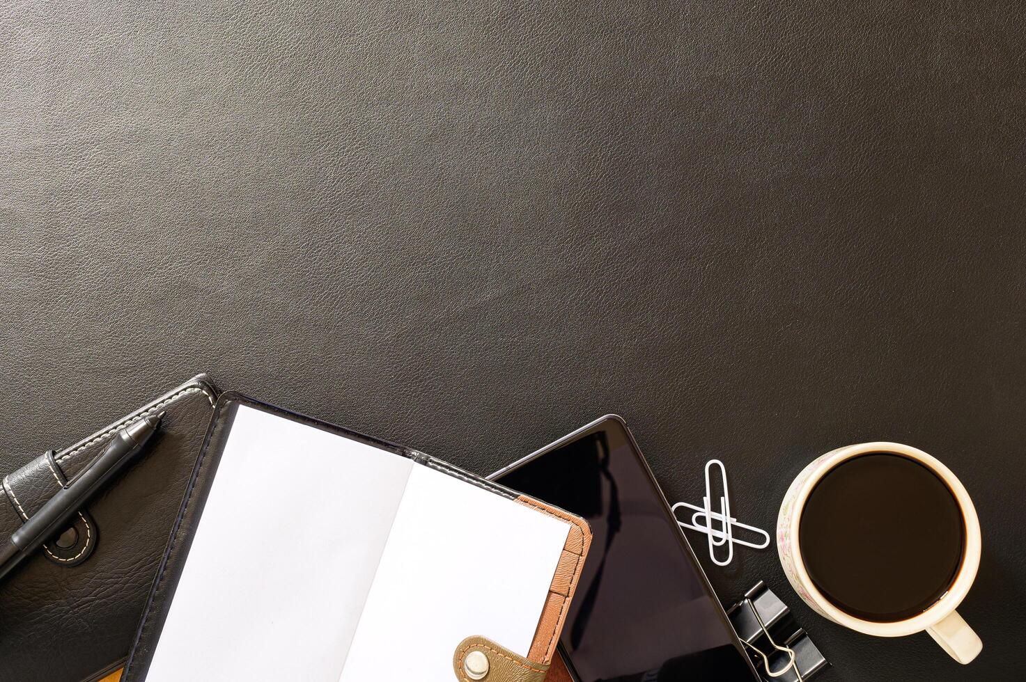 Black desk with coffee and office tools photo