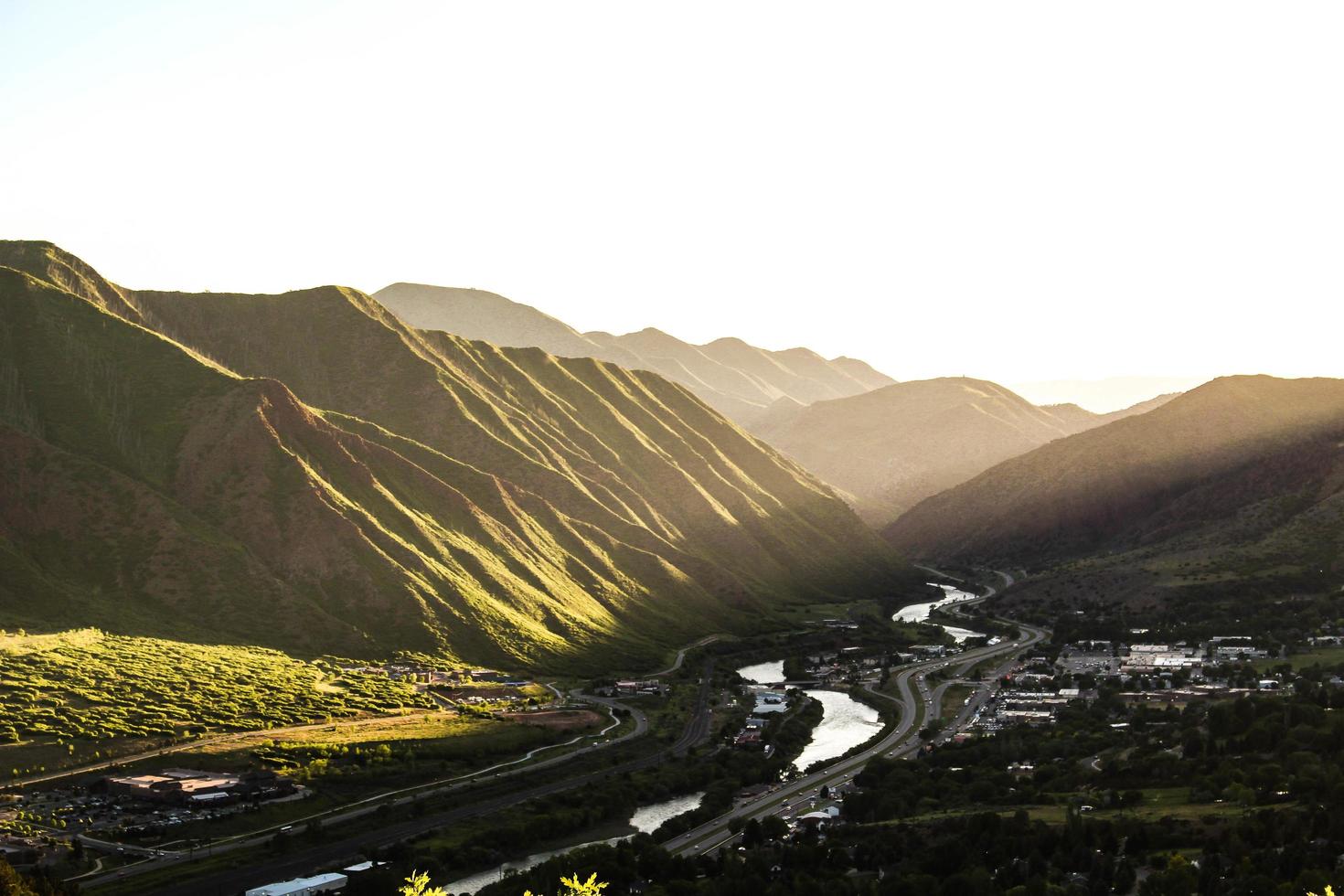 Stream running through a valley of green mountains photo