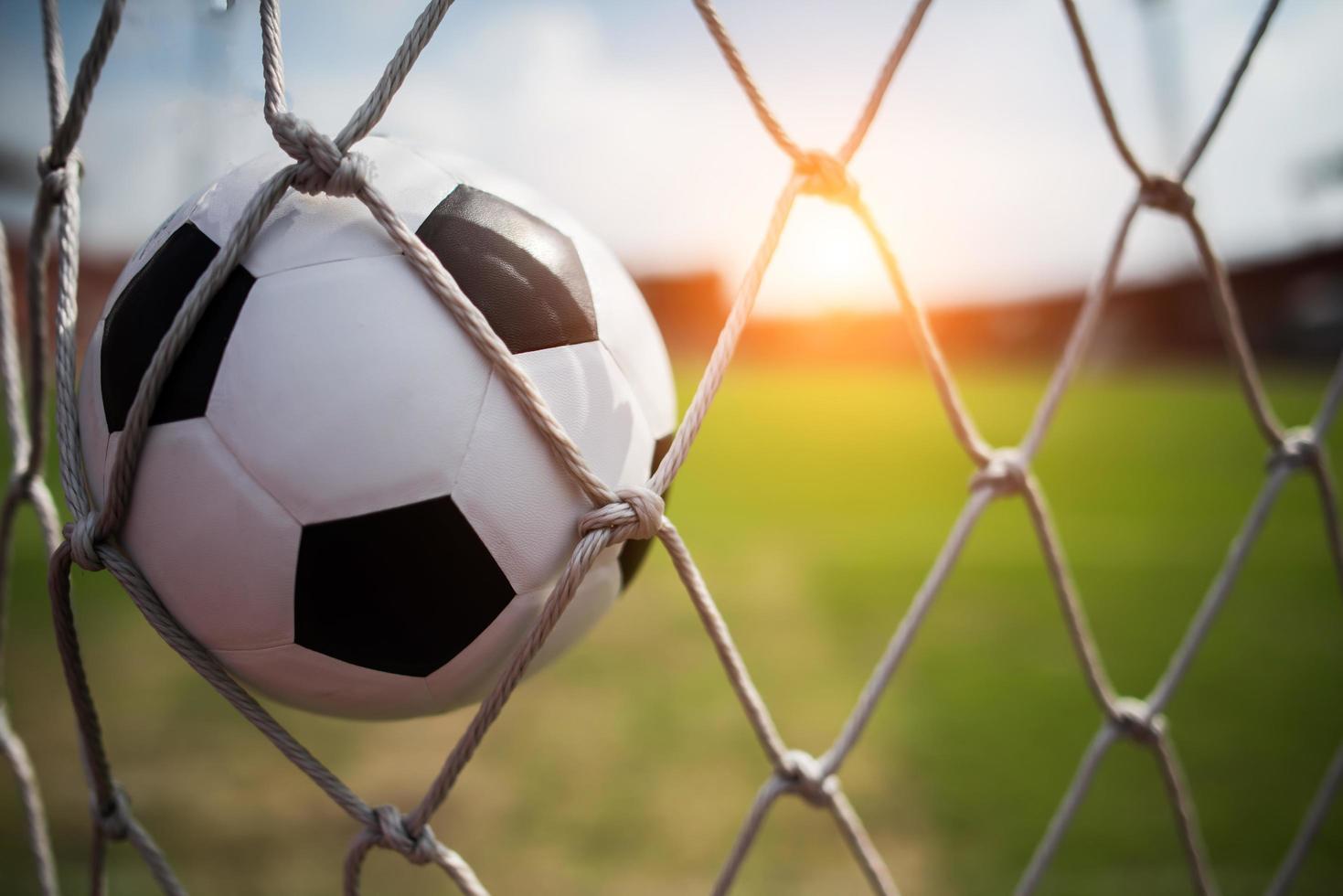 balón de fútbol se eleva a la red de la portería foto