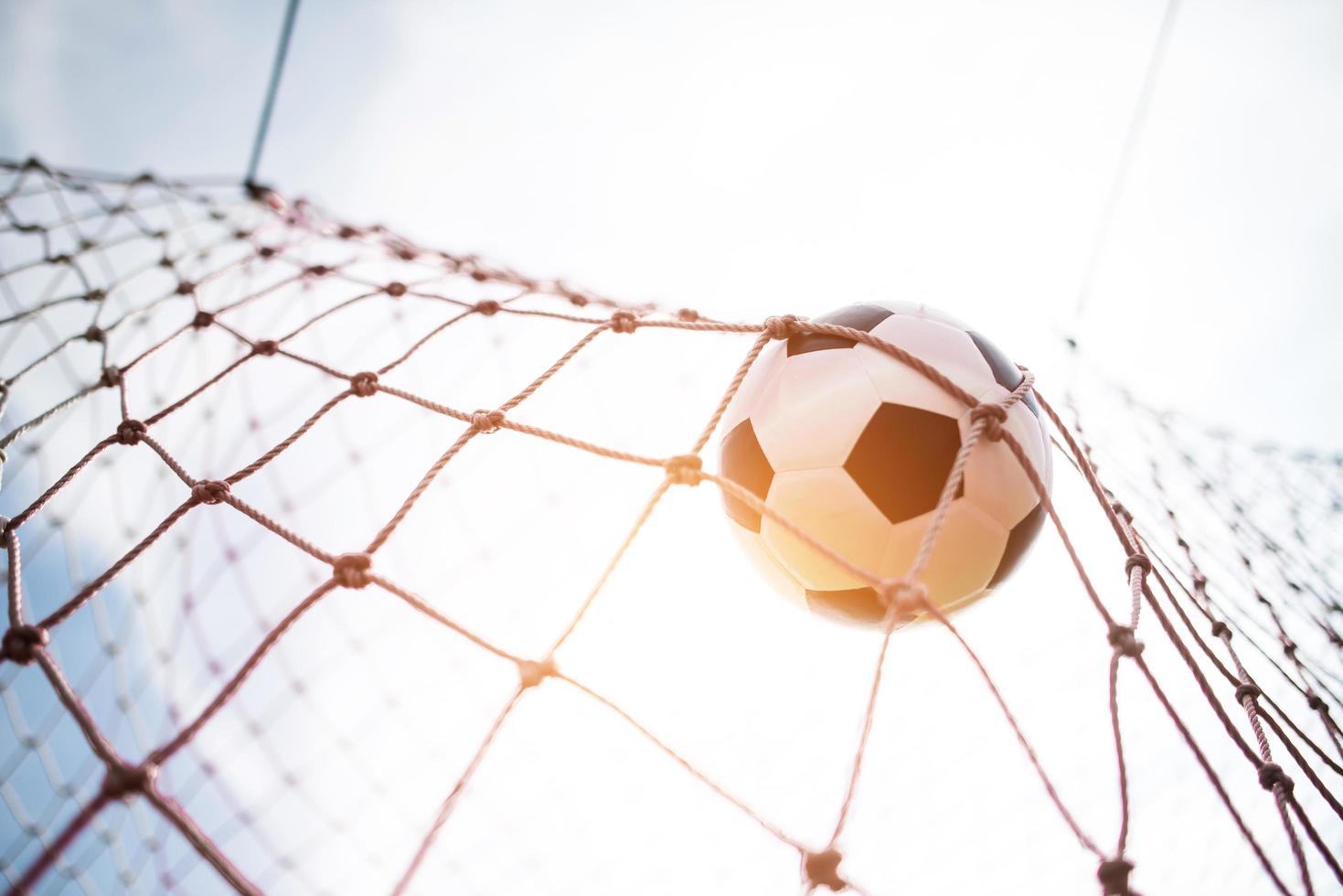 Soccer ball soars into goal net photo