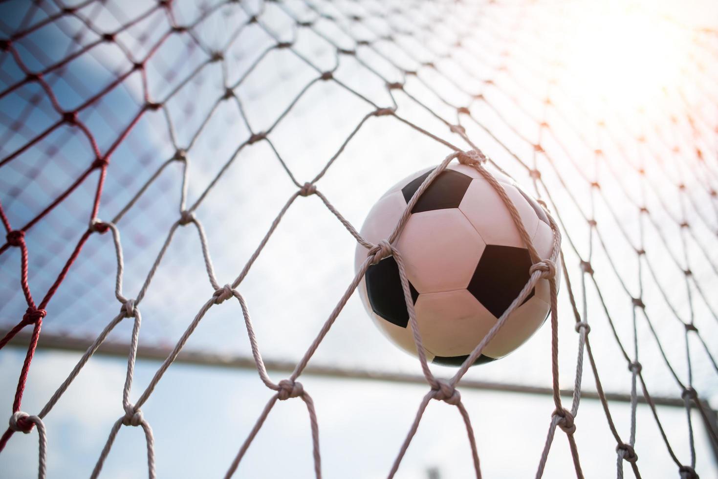 Soccer ball soars into goal net photo